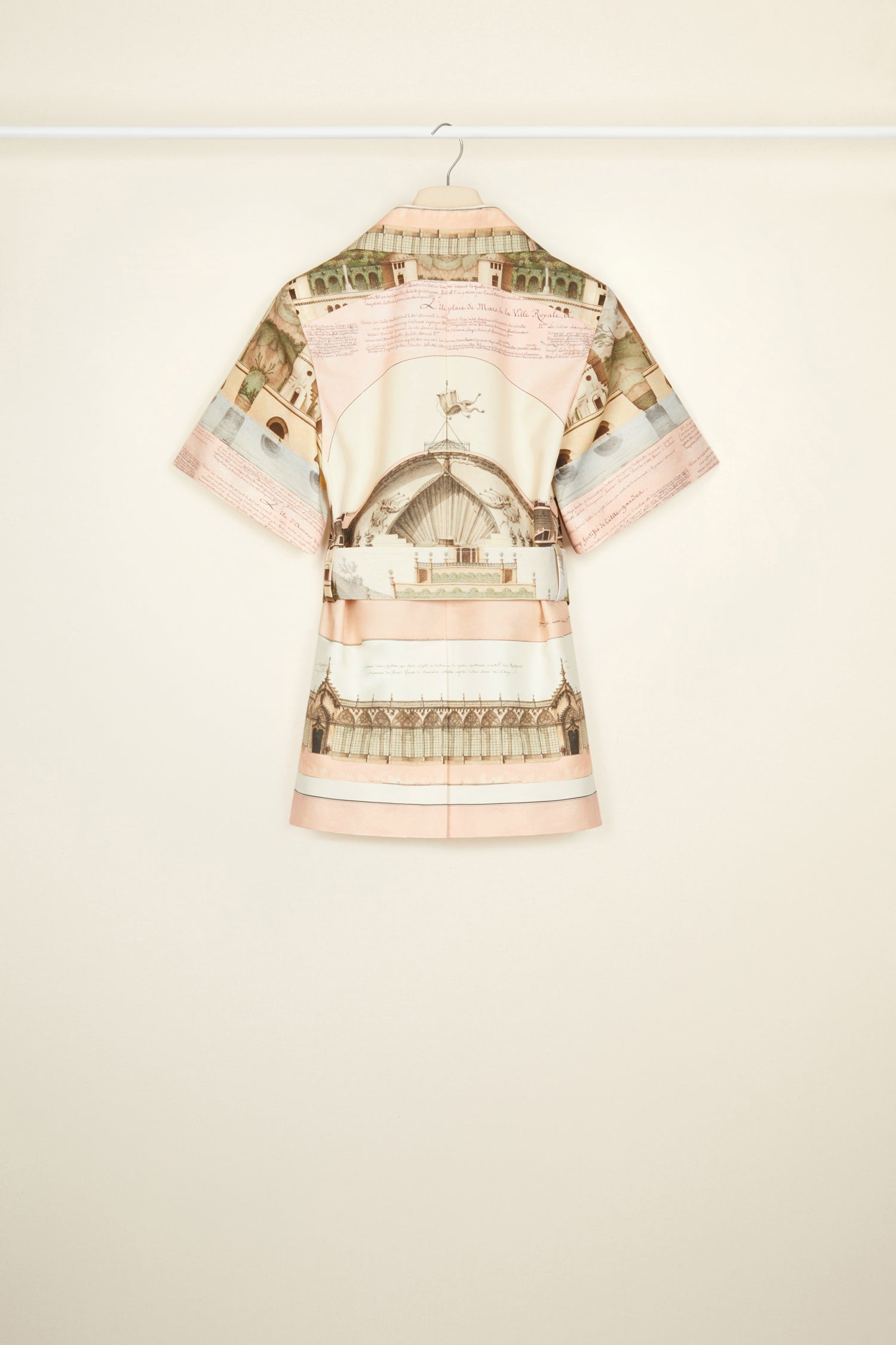 Patou - Belted short sleeve jacket in printed organic cotton and wool - Amour Island - Tailoring with a smile? Très Patou. Organic cotton and wool jacket featuring Jean-Jacques Lequeu's “Amour Island” print. Spread collar. Short sleeves with Patou label on the left cuff. Button fastening with fabric covered buttons. Curved seams at the bust with chest darts. Wide adjustable belt with fabric-covered. Seam pockets at the sides. Single vent at the back.