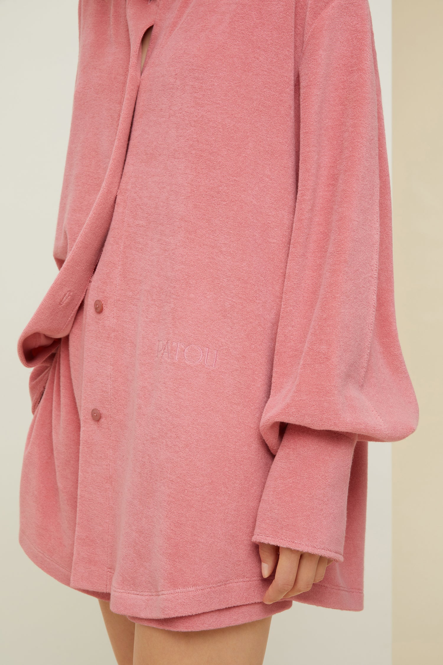 Patou - Oversized terry shirt in organic cotton blend - Antique Pink - Smile harder, dress softer.Antique Pink terry shirt in organic cotton blend. Loose longline silhouette. Shirt collar. Button fastening with JP engraved buttons at the front. Signature curved seam and knife pleats at the back. Long sleeves with volume at the cuffs.