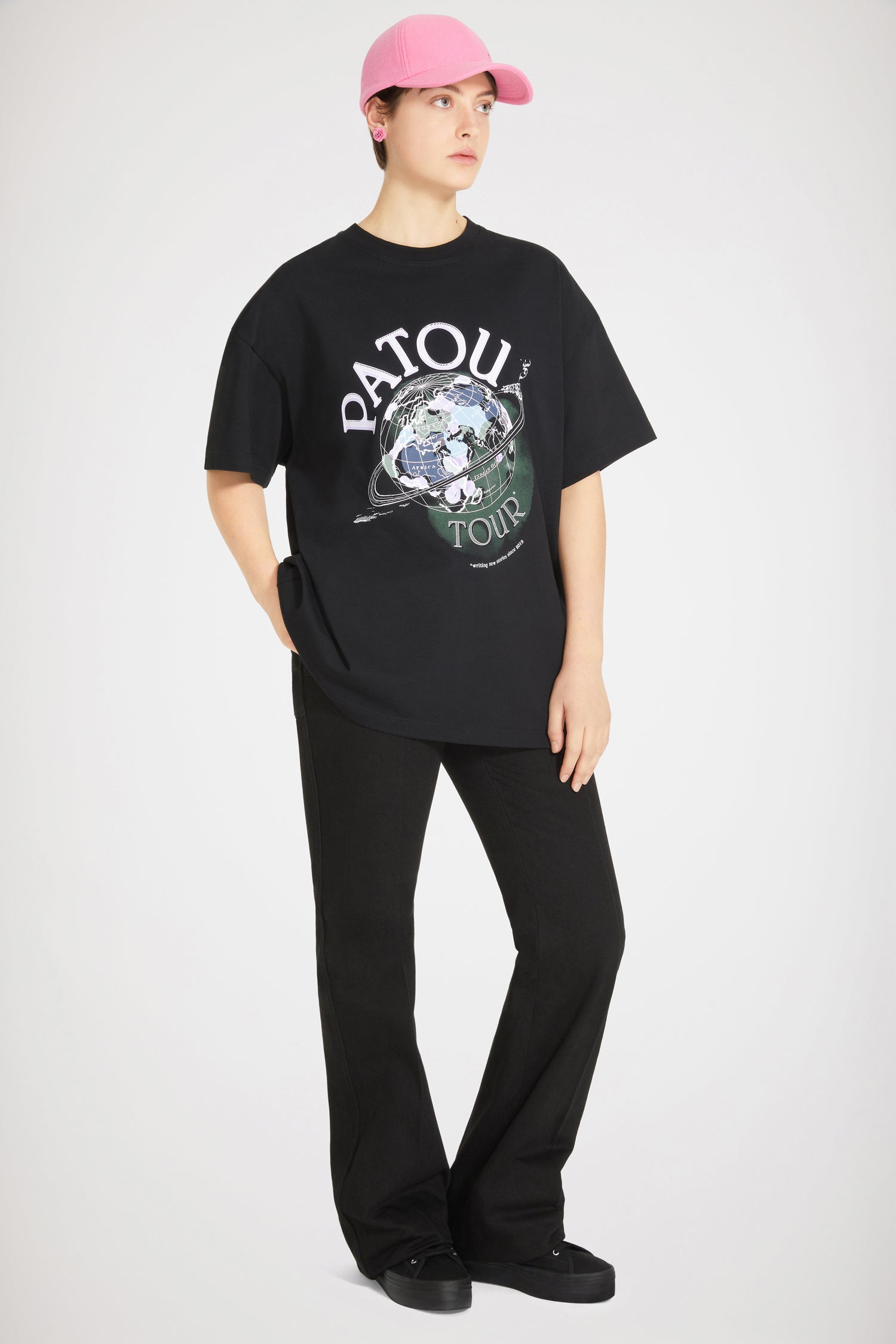 Patou - Maglietta Patou Tour in cotone bio - Black - Nuove avventure in tutto il mondo dal 2019. Maglietta in cotone bio nero. Vestibilità oversize. Stampa Patou Tour con logo e mappamondo. Monogramma JP sul retro. Look unisex (per gli uomini: prendere una taglia in più).