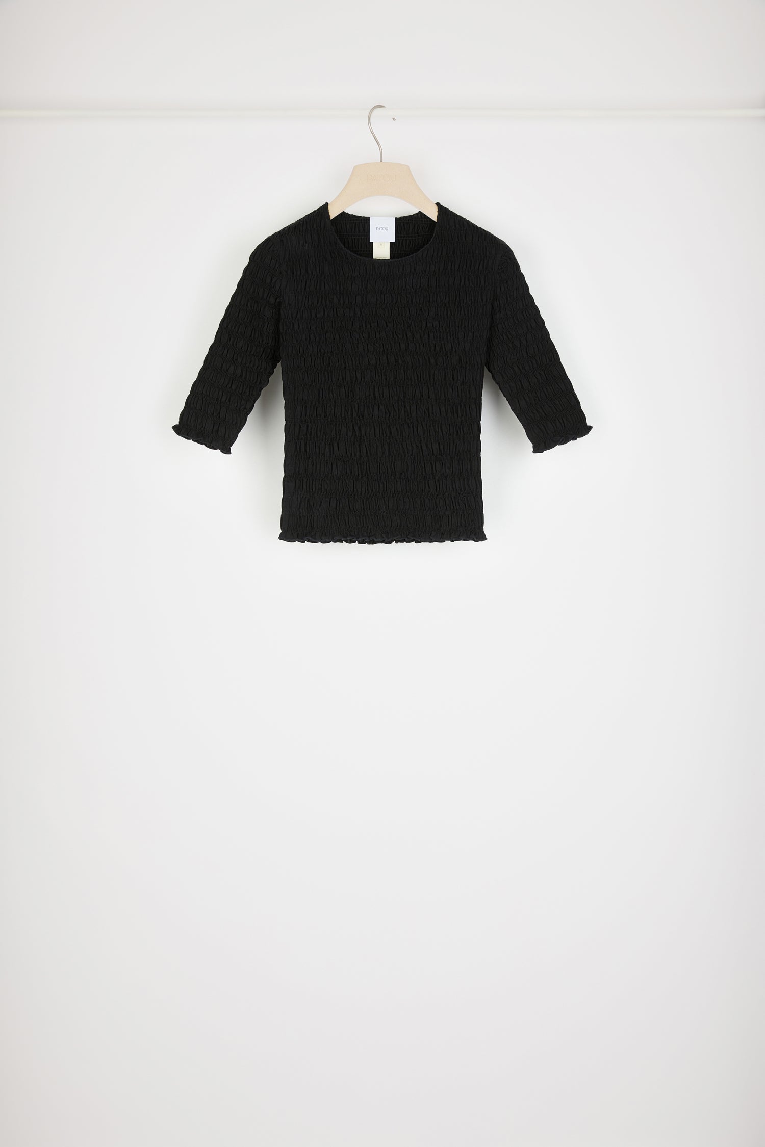 Patou - Smock top in organic cotton - Black - Looking smockin', feeling gorgeous.Black organic cotton top. Fitted style. Smocked detailing all over. Round neckline. Mid-length sleeves. Tonal JP monogram appliqué at the back.This top is very skin-tight and fitted.Spring-Summer 2023 Show - Look #17