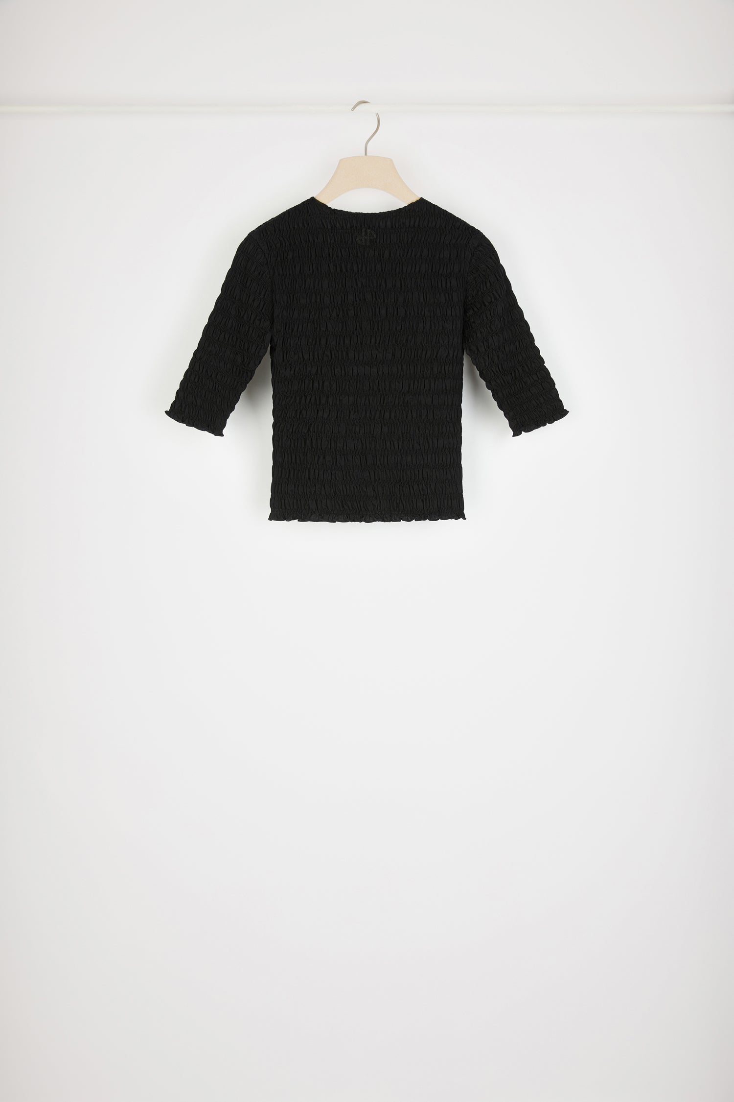 Patou - Smock top in organic cotton - Black - Looking smockin', feeling gorgeous.Black organic cotton top. Fitted style. Smocked detailing all over. Round neckline. Mid-length sleeves. Tonal JP monogram appliqué at the back.This top is very skin-tight and fitted.Spring-Summer 2023 Show - Look #17