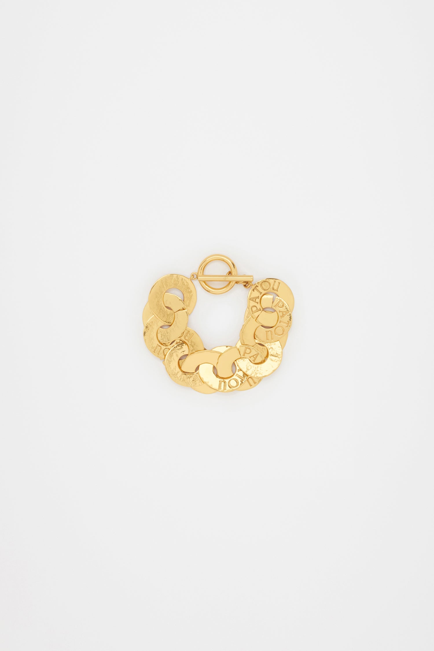 Patou - Coin bracelet in gold-plated brass - Gold - Gold-plated brass bracelet. Antique coin inspiration. Hammered texture. Interlinked coin chain with-engraved Patou logo. T-bar closure.