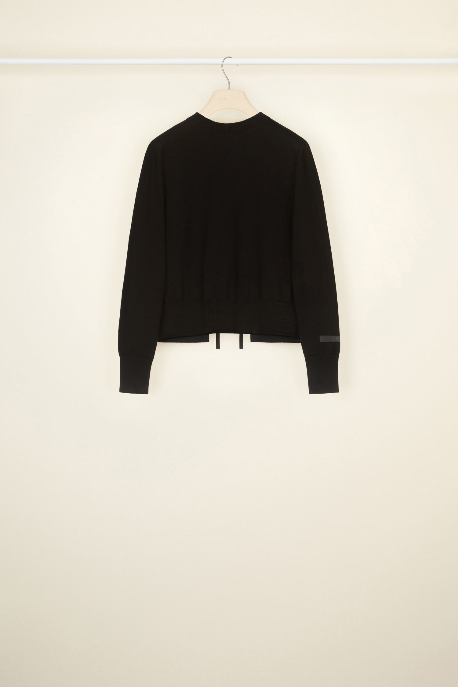 Patou - Pull dos nu en laine éco-responsable et coton bio - Black - Le dos nu domine.Pull en laine éco-responsable et coton bio noir. Coupe classique. Col rond. Col, poignets et ourlet côtelés. Dos nu avec fermeture par lacets à l’encolure et à la taille. Étiquette Patou blanche brodée à l’avant.