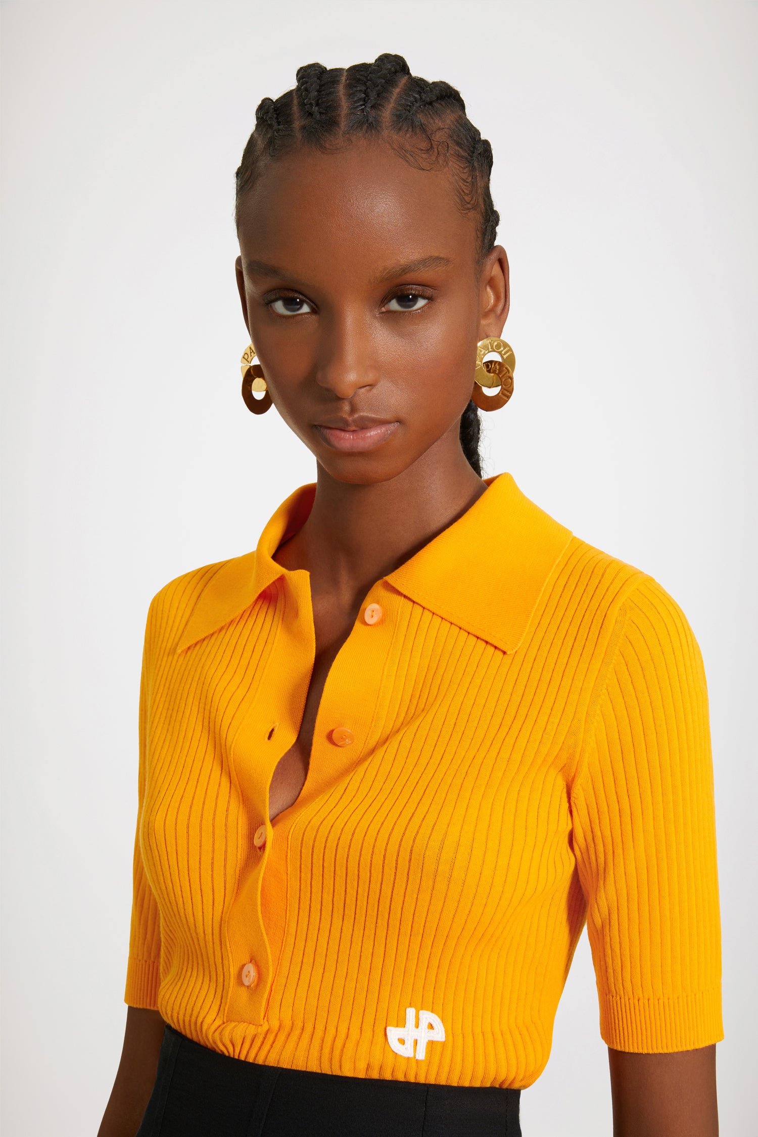 Patou - Polo in maglia di cotone bio - Marigold - La polo firmata Patou.Polo in cotone bio arancione calendula. Modello a coste che sottolinea la vita. Collo polo con bottoni incisi JP. Maniche corte. Logo JP bianco sul fronte.