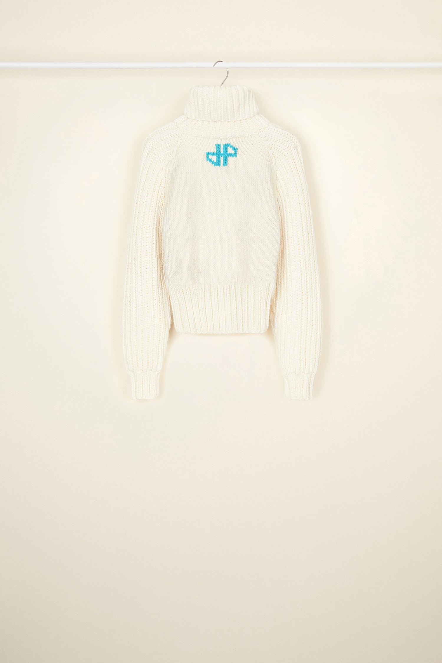 Patou - Patou Neige wool jumper - Ivory - Smile for the winter in the cosiest Patou jumper. Ivory Merino wool jumper. Part of the Patou Neige collection. Hand knitted garment featuring multiple stitch styles. Cropped, fitted silhouette. Turtleneck collar. High volume sleeves. Black Patou Neige signature and handwriting logo.