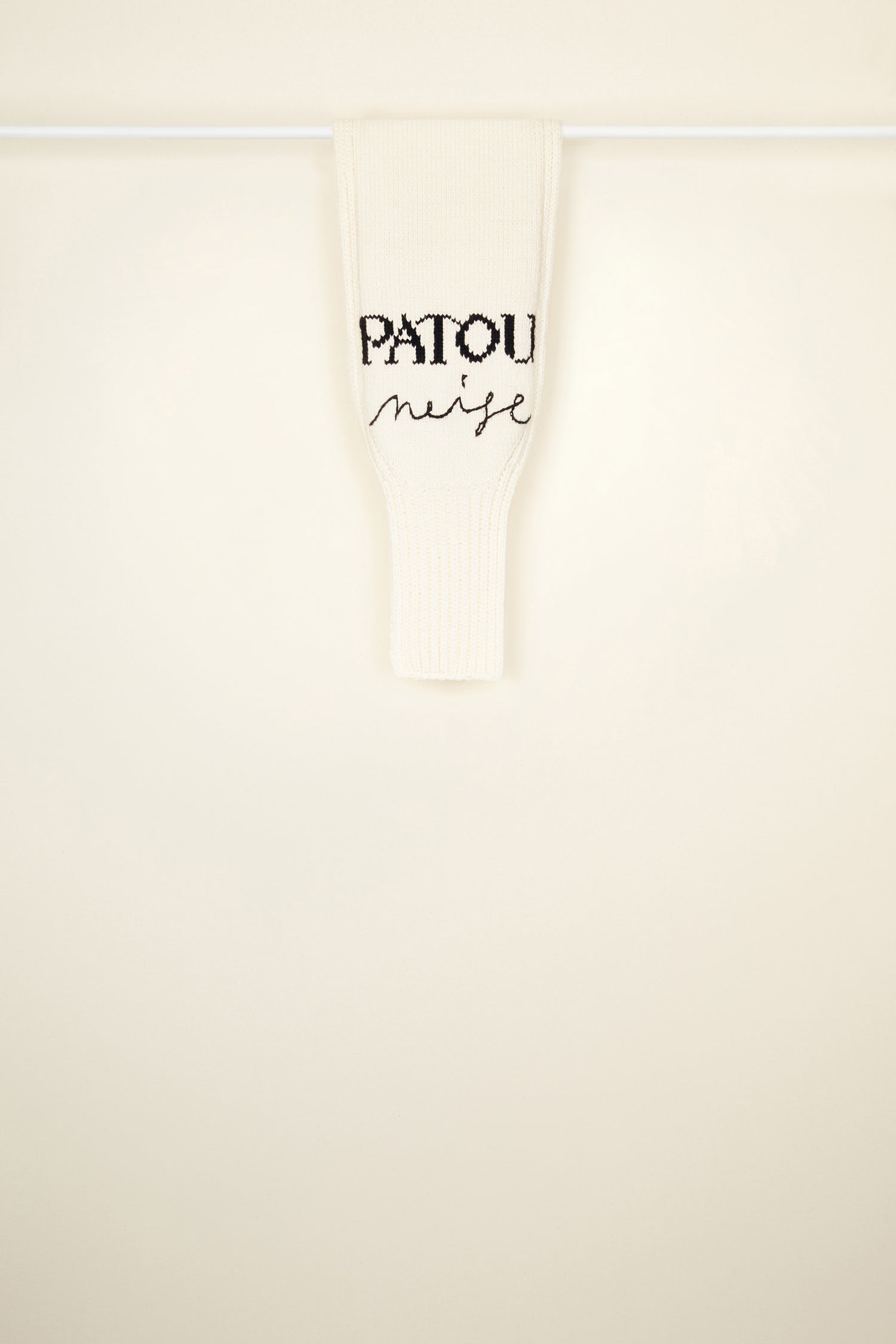 Patou - Patou Neige Wollschal - Ivory - Wunderbar warm mit besonders viel Charme. Schal aus Merinowolle in Elfenbein. Teil der Patou Neige Kollektion. Handgestrickt. Aufgesticktes schwarzes Patou Neige Schriftzug- und Handschriftlogo. Aufgesticktes JP-Monogramm in Blau. Kann offen oder geknotet getragen werden.