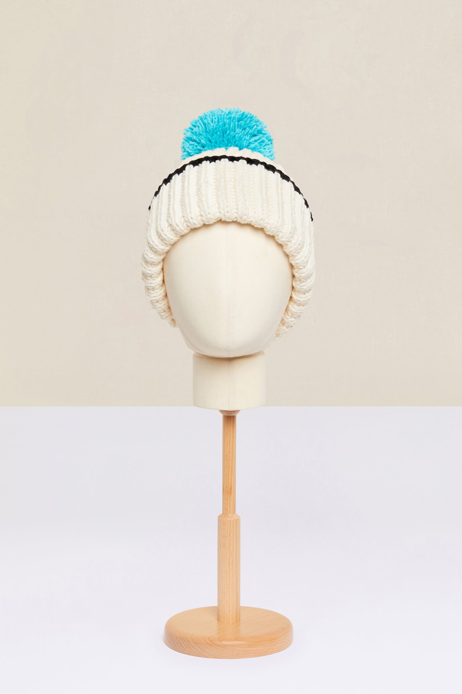 Patou - Bonnet en laine Patou Neige - Ivory - Le pompom Patou réchauffe les tenues d’hiver.Bonnet en laine vierge ivoire. Modèle de la collection Patou Neige. Tricoté à la main. Pompom bleu. Revers avec bordure noire.