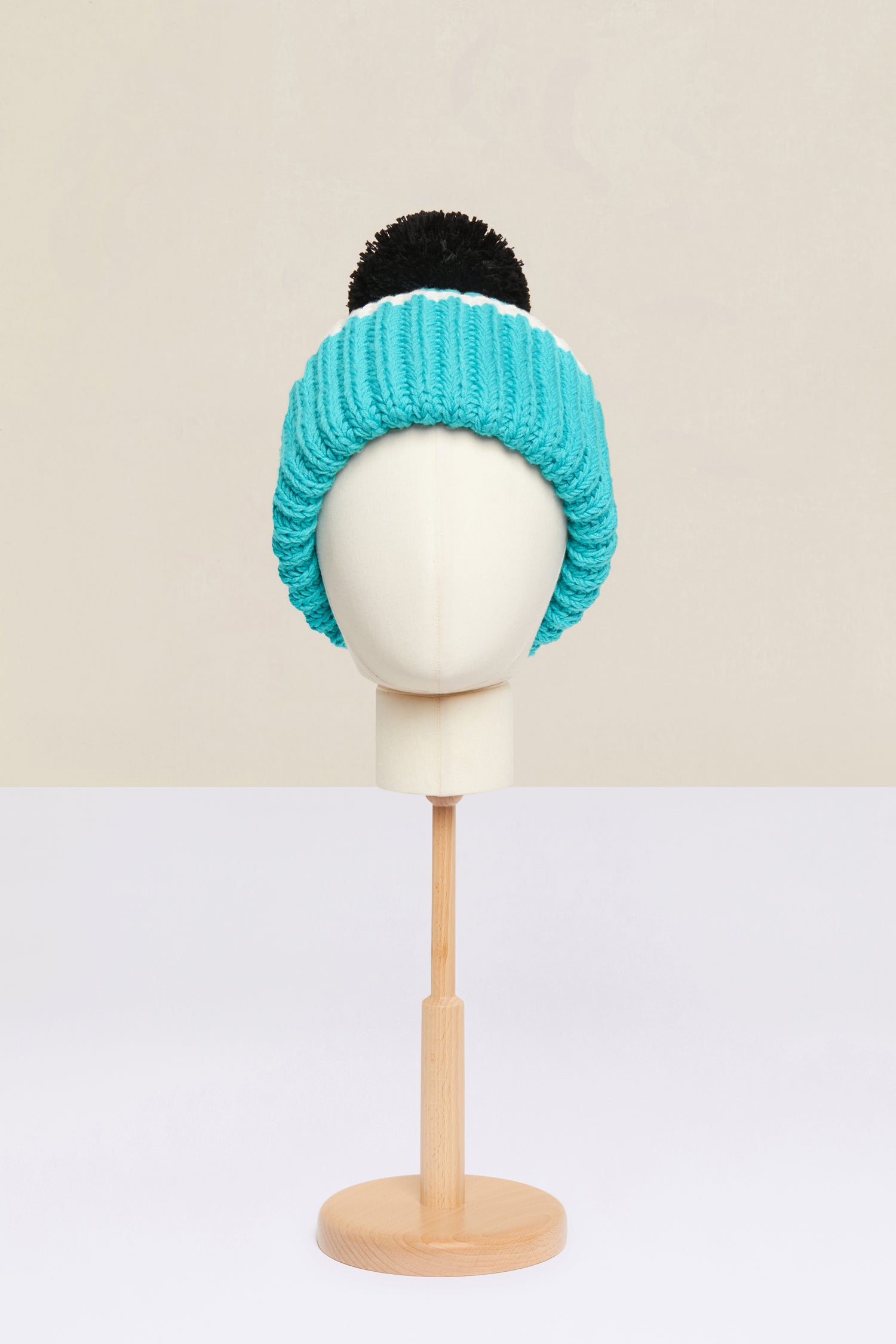 Patou - Bonnet en laine Patou Neige - Blue - Le pompom Patou réchauffe les tenues d’hiver.Bonnet en laine vierge bleue. Modèle de la collection Patou Neige. Tricoté à la main. Pompom noir. Revers avec bordure blanche.