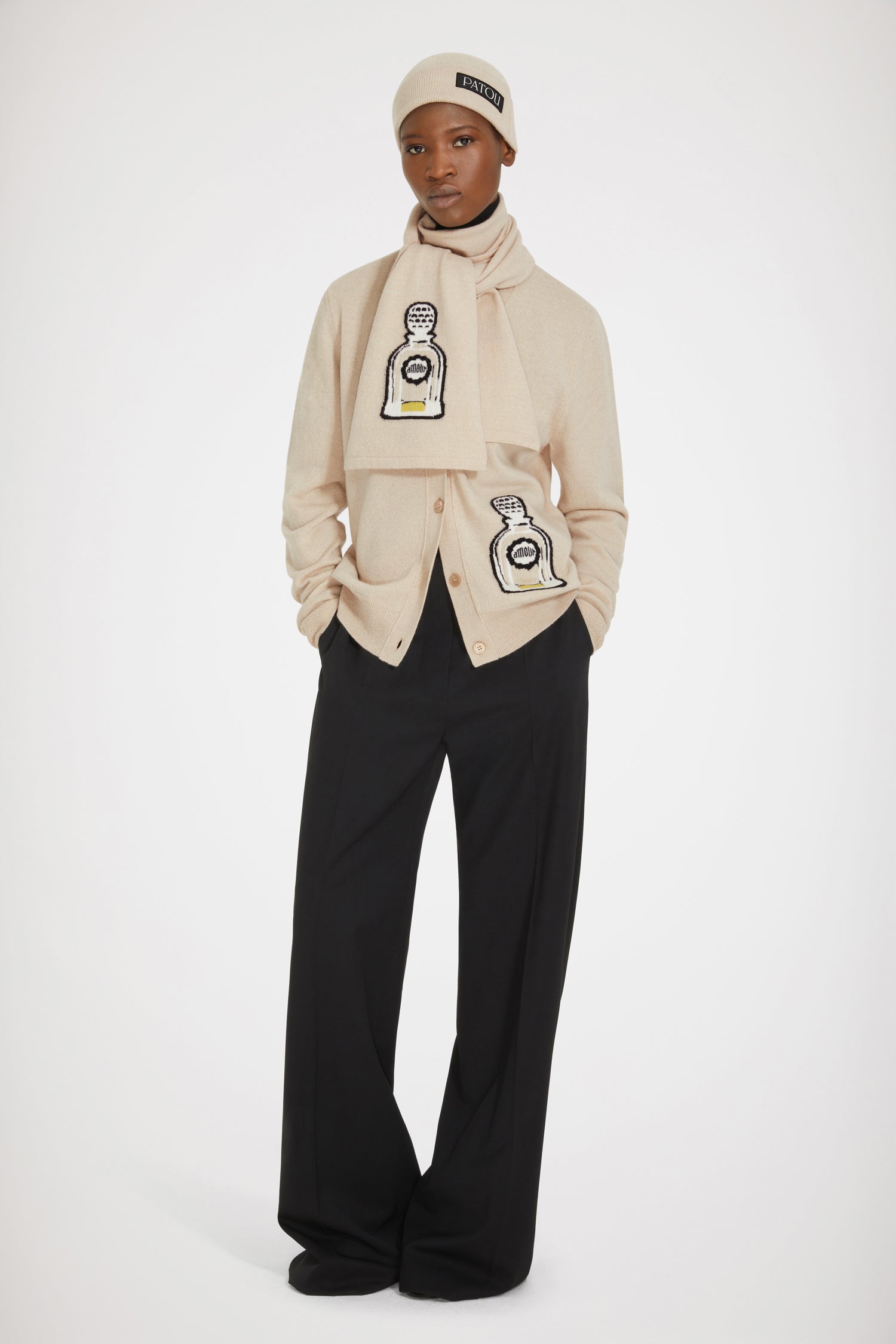 Patou - Cardigan in lana con diisegno di profumo - Biscuit - Un oggetto iconico trasforma un grande classico.Cardigan in lana e cachemire beige biscotto. Vestibilità ampia. Scollo a V. Bottoni sul davanti. Disegno di profumo lavorato a intarsio con ispirazione agli archivi Jean Patou.
