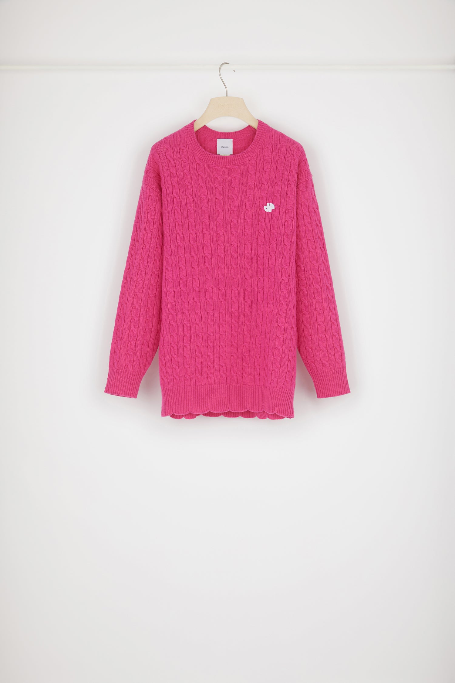 Patou - Maglione JP con trecce in lana - Fuchsia - Le trecce avvolgono il monogramma JP.Maglione in lana merino fuchsia. Dettaglio di trecce. Modello lungo. Collo tondo. Monogramma JP bianco sul davanti. Orlo a scaloppina. Vestibilità ampia (seleziona una taglia in meno per un look aderente).