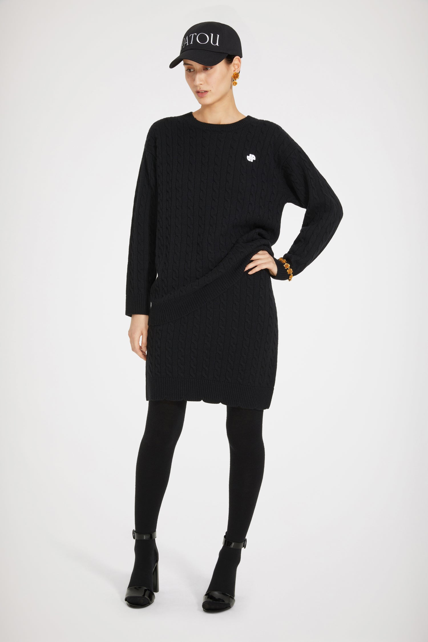 Patou - JP-Pullover mit Zopfmuster aus Merinowolle - Black - Ein Zopfmuster mit dem Gütesiegel von JP.Pullover aus Merinowolle in Schwarz. Zopfmuster. Lang geschnitten. Rundhalsausschnitt. Weißes JP-Logo an der Brust. Gewellter Saum.Lockerer Schnitt (für einen körperbetonteren Stil bitte eine Größe kleiner wählen).