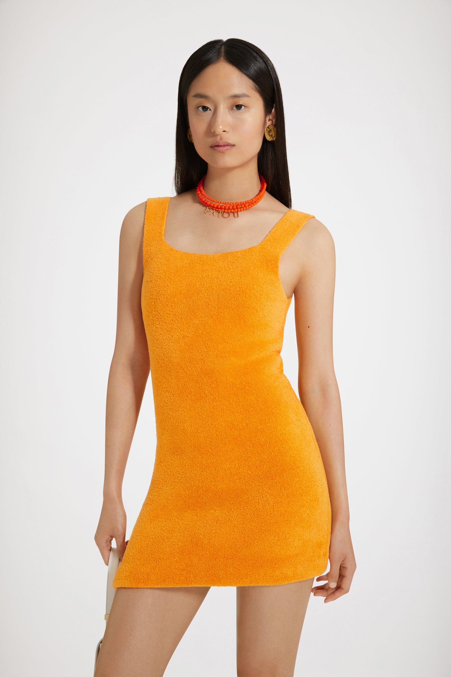 Patou - Textured knit mini dress - Marigold - Terrycloth goes couture.Marigold orange viscose and organic cotton-blend knit dress. Terrycloth-like texture. Fitted silhouette. Short length. Wide straps with slight scoop neckline. Spring-Summer 2023 Show - Look #24