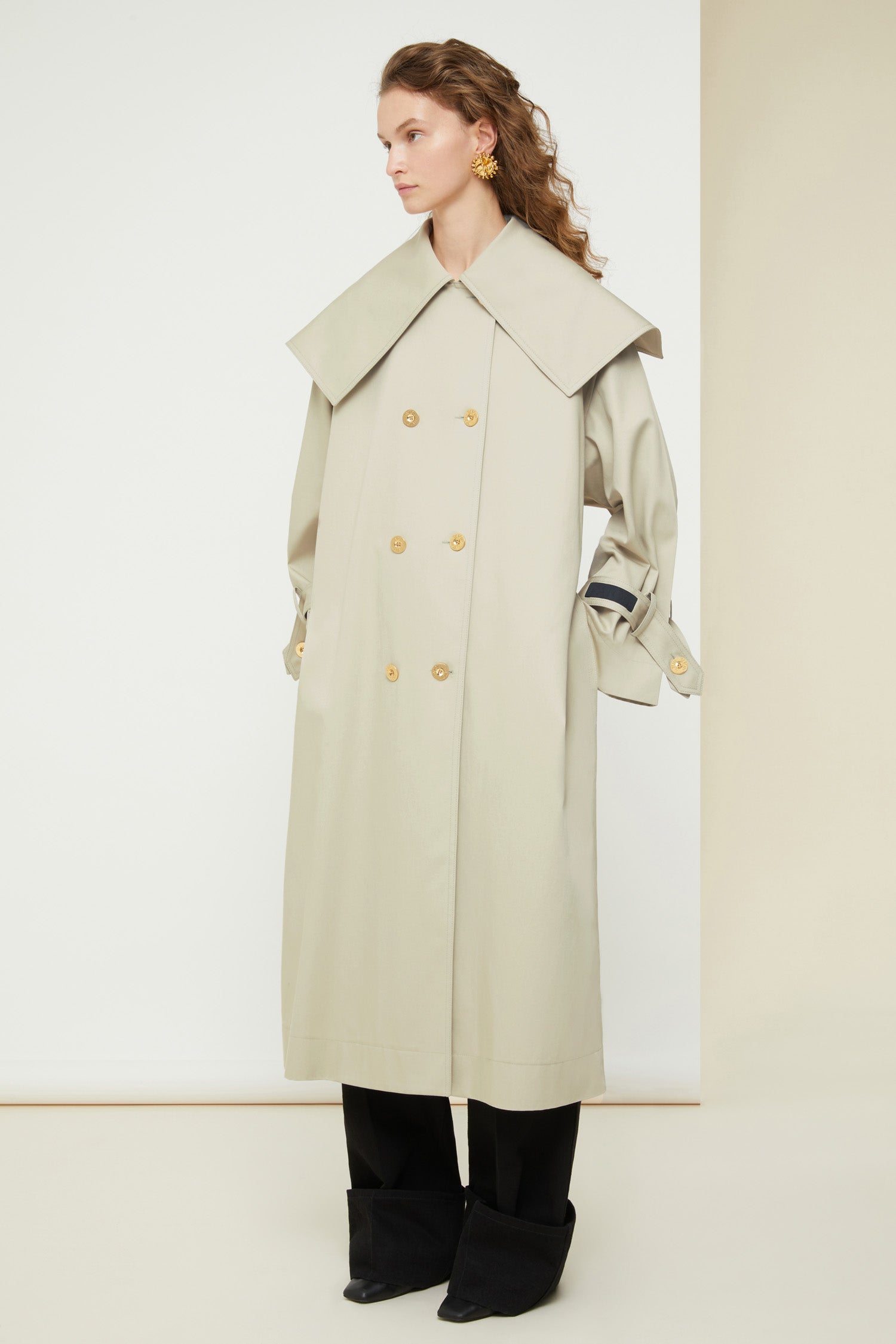 Patou - Signature trenchcoat in organic cotton - Silvery Moon - A flared trench with French flair.Signature Patou trenchcoat in Silvery Moon pale grey organic cotton gabardine. Double-breasted style with a slight A-line silhouette. Oversized collar and storm flap. Gold-coloured buttons with engraved Patou logo. Removable belt at the waist. Ties at the cuffs with black embroidered Patou label. Two pockets at the sides. Fully lined. Oversize fit.