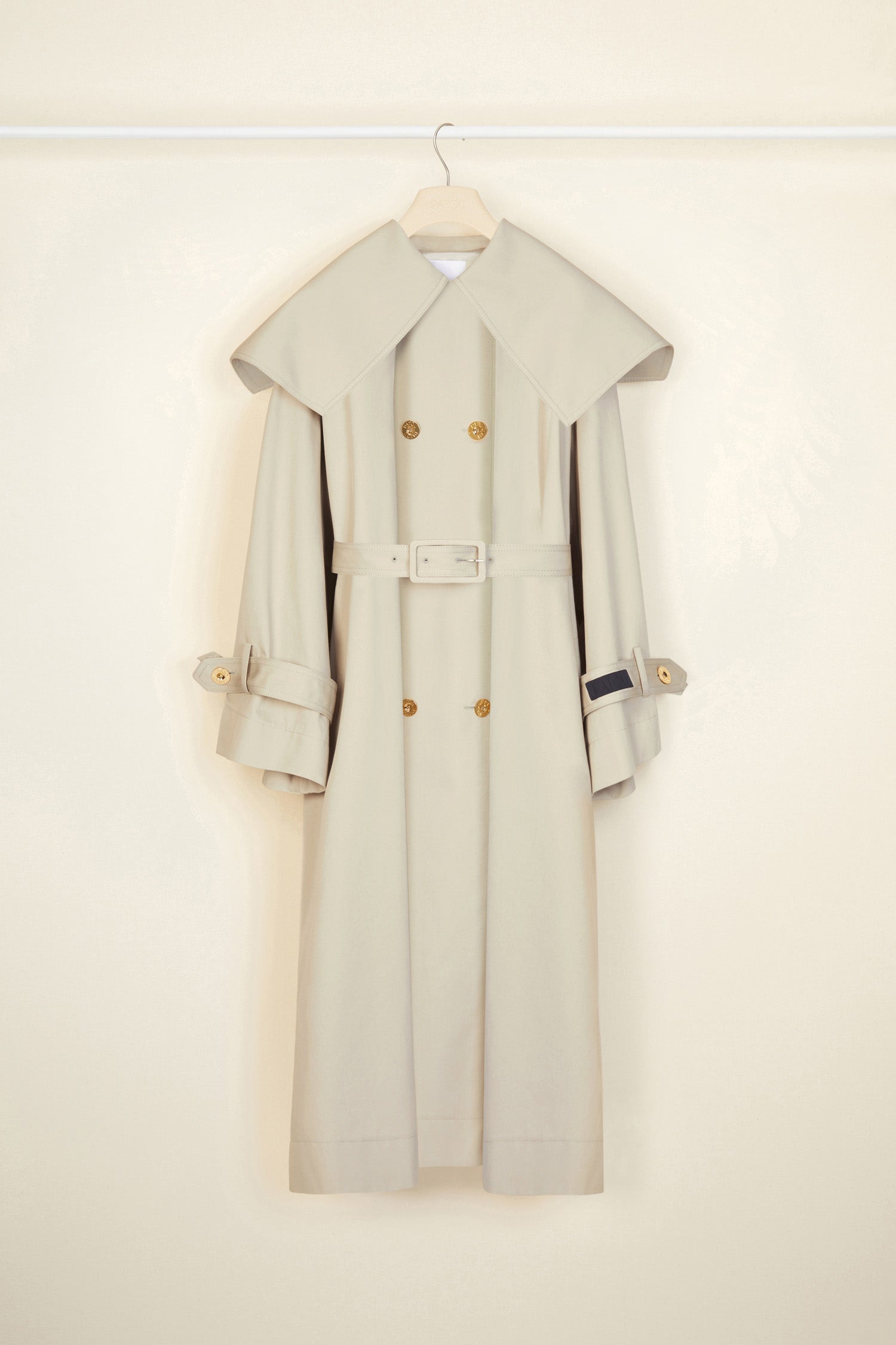 Patou - Signature trenchcoat in organic cotton - Silvery Moon - A flared trench with French flair.Signature Patou trenchcoat in Silvery Moon pale grey organic cotton gabardine. Double-breasted style with a slight A-line silhouette. Oversized collar and storm flap. Gold-coloured buttons with engraved Patou logo. Removable belt at the waist. Ties at the cuffs with black embroidered Patou label. Two pockets at the sides. Fully lined. Oversize fit.