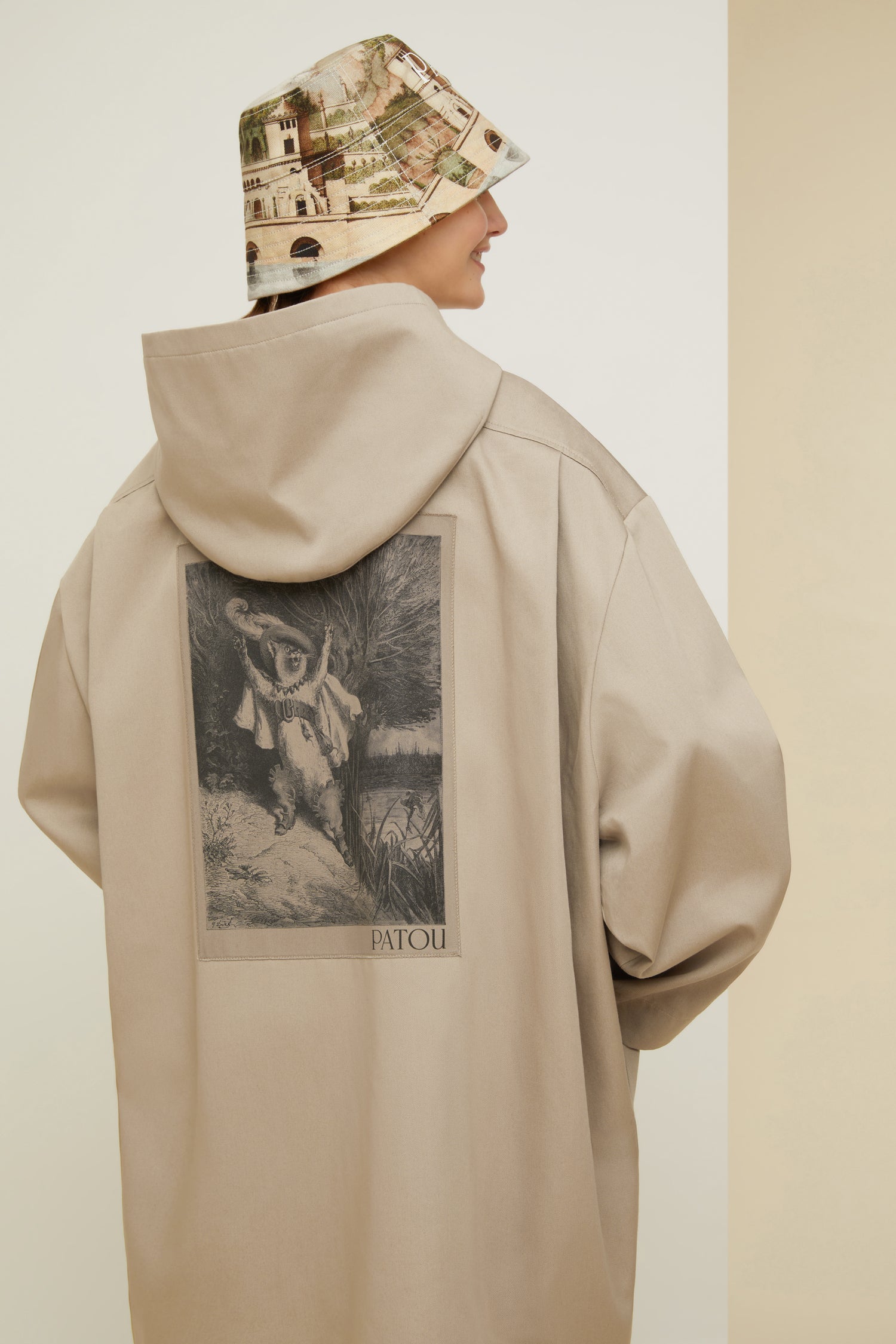 Patou - Puss in Boots oversized parka in organic cotton - Parchment - Ready to brave the elements with a smile. So Patou!Parchment beige organic cotton parka. Oversized silhouette. Hooded collar. Dropped embossed shoulders. Stud button fastening at the front. Large patch pockets. Patou lettering logo embroidered on the left pocket. Classic “Puss in Boots” illustration by Gustave Doré and Patou lettering logo printed at the back.Loose fit (select one size down for a fitted look).