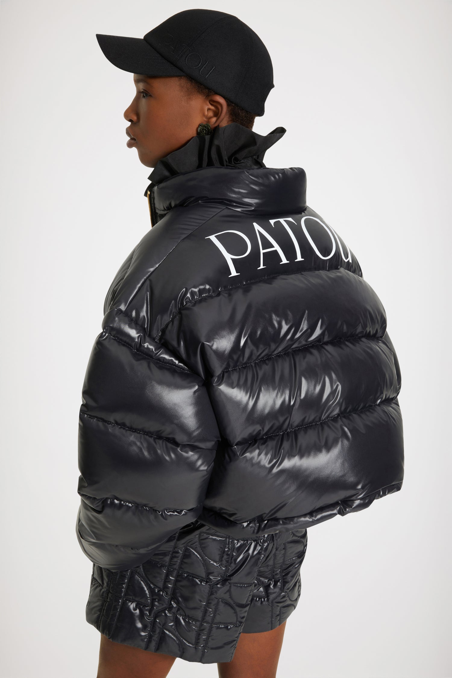 Patou - Patou puffer jacket - Black - A puffer named Patou. Black polyester blend jacket. Short padded style. High collar. Gold-tone zip with JP puller inspired by a heritage keyring from the Jean Patou archive. Large Patou logo across the back. Pockets at the sides. Drawstring waist. Elasticated cuffs.