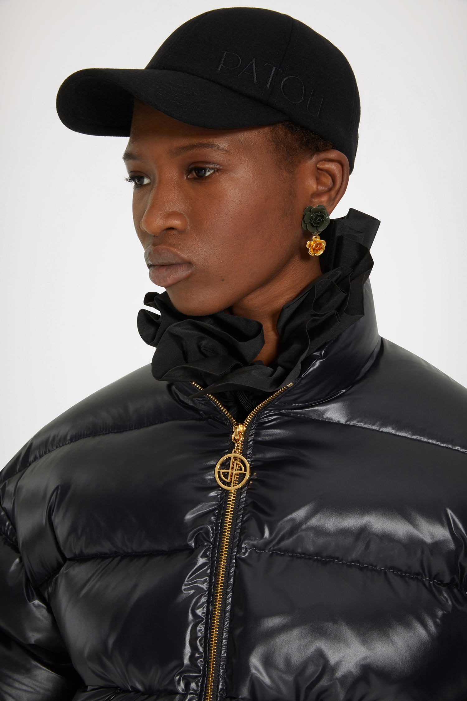 Patou - Patou puffer jacket - Black - A puffer named Patou. Black polyester blend jacket. Short padded style. High collar. Gold-tone zip with JP puller inspired by a heritage keyring from the Jean Patou archive. Large Patou logo across the back. Pockets at the sides. Drawstring waist. Elasticated cuffs.