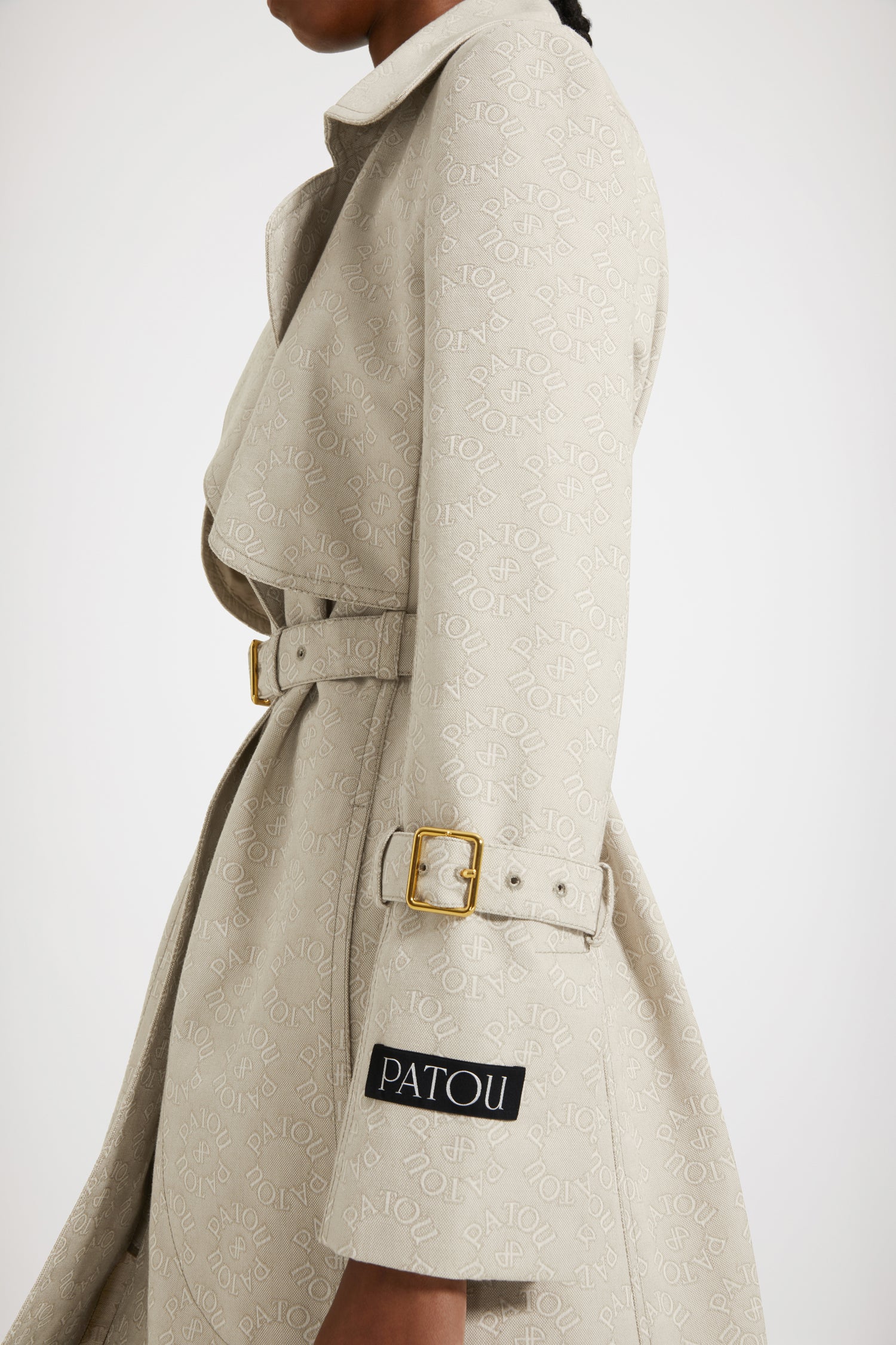 Patou - Trench in jacquard di cotone bio - Medallion - Patou firma il perfetto trench alla francese.Trench in jacquard di cotone bio. Fantasia Medaglione con logo Patou e monogramma JP. Modello monopetto. Lunghezza al ginocchio. Pattina frangivento sul davanti. Bottoni oro incisi Patou. Cintura regolabile con fibbia oro in vita. Tasche a toppa con apertura laterale. Polsini con cinturino. Etichetta Patou signature sulla manica sinistra. Cucitura curva signature sul retro. Spacco posteriore con bottone oro inciso Patou.Spring-Summer 2023 Show - Look #14