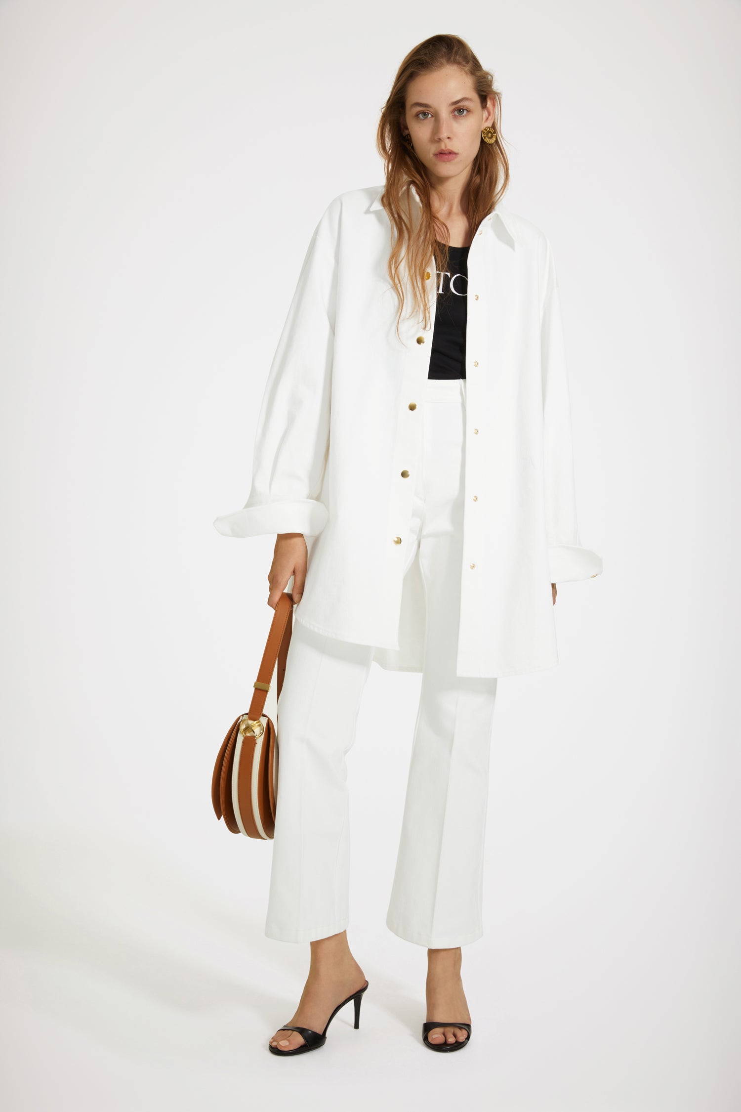 Patou - Overshirt in cotton denim - White - An oversized overshirt to layer over your every look.White cotton denim overshirt. Oversized silhouette with balloon sleeves. Gold-tone press buttons down the front and at the cuffs. Embroidered Patou logo at the front. Signature curved seam at the back.