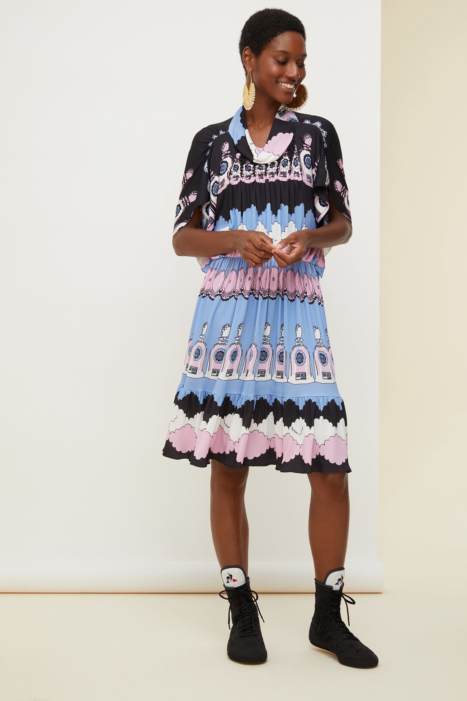 Patou - Robe midi imprimée à smocks - Cloud Print - Les icônes Patou ont la tête dans les nuages.Robe midi en jersey à imprimé "Cloud" figurant des objets iconiques de l'histoire Patou. Encolure souple façon cheminée. Smocks à l'avant. Manches et ourlet tulipe.