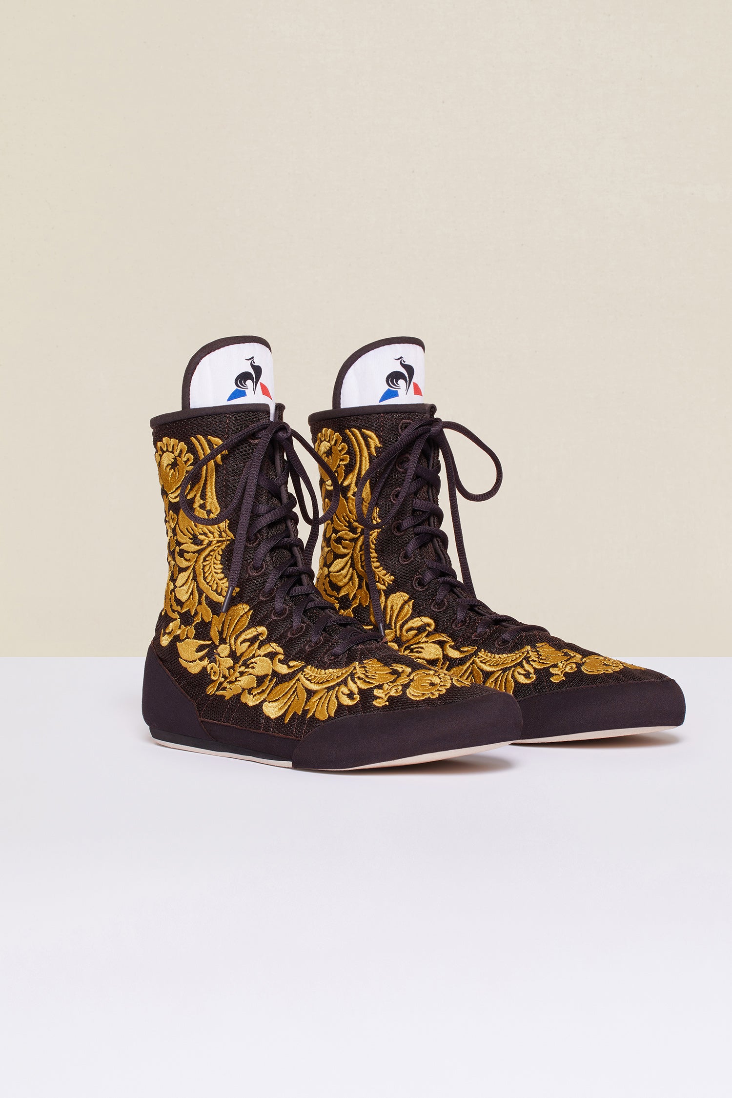 Patou - Embroidered high-top trainers - Havana - Havana - Couture florals are stepping in the ring!Ongoing collaboration between Patou and Le Coq Sportif. Brown high-top trainers inspired by classic boxing shoes. Gold floral embroideries. Patou logo engraved on the heel. Original Le Coq Sportif logo on the tongue. Flexible rubber sole with embossed Patou logo.