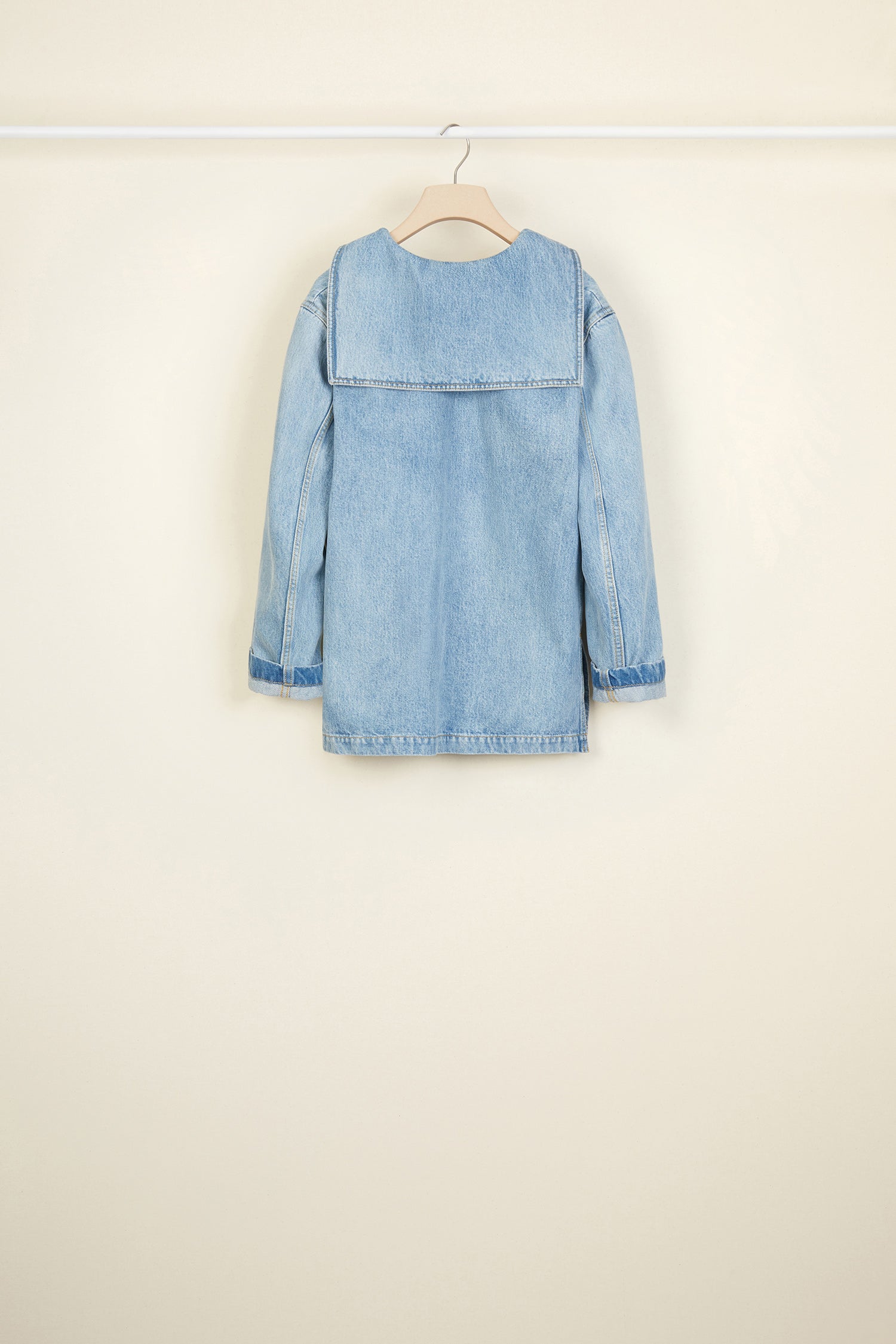 Patou - オーガニックデニム セーラー チュニック - Blueberry - デニムが遠い海に出る。ライトウォッシュ オーガニックデニム チュニック。コレクションのテーマである船をイメージ。セーラーカラー、深いVネックライン、フロントに取り外しできないボタンタブ。背中にシグネチャーのフラップ。裾が広がったシルエット、サイドにスリット。全体にコントラストカラーのステッチ。