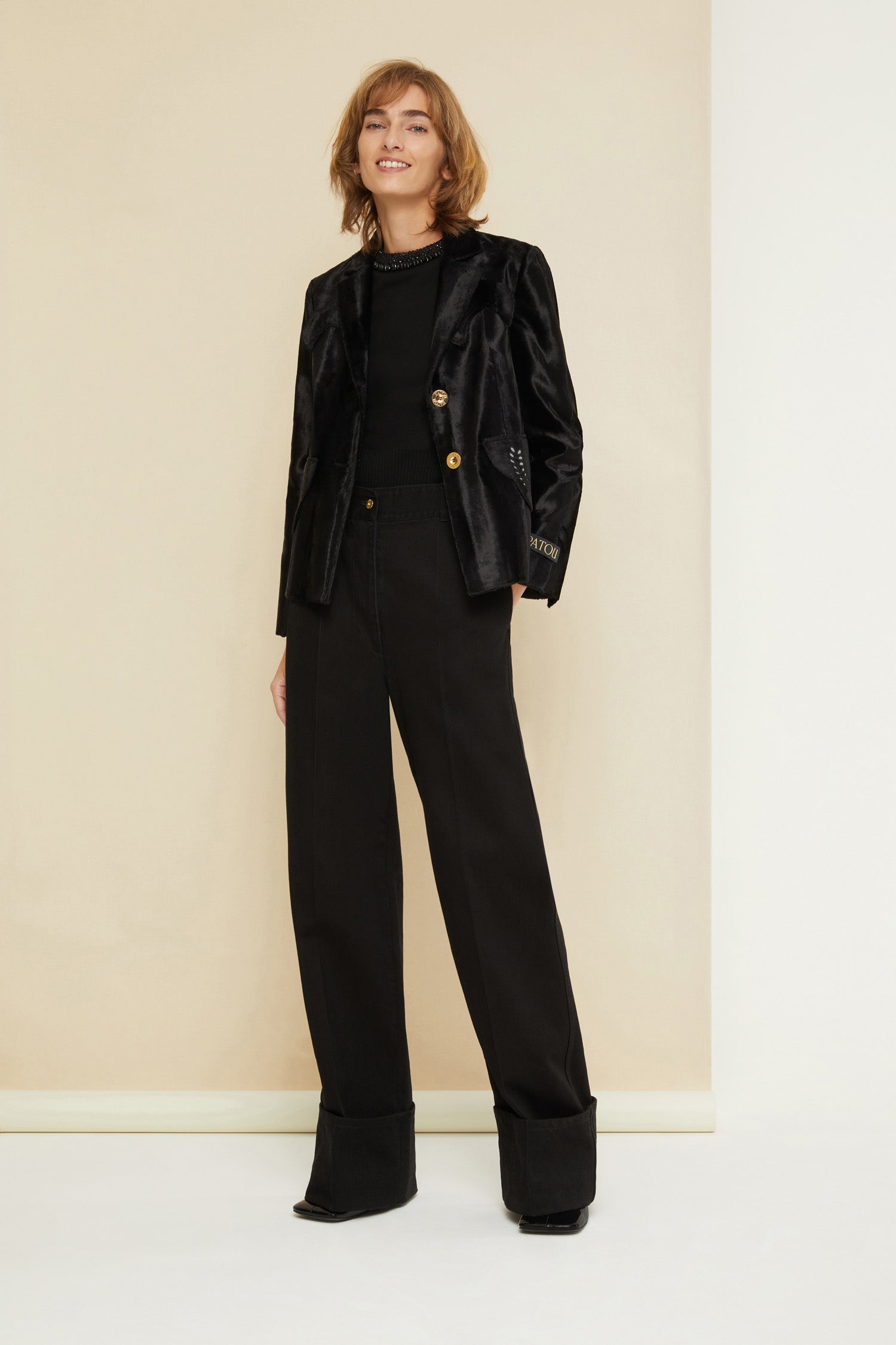 Patou - Cuffed wide-leg trousers in organic denim - Black - Cuffed and loose: denim elevated by Patou. Black organic denim trousers. Wide-legged style. Button fastening with belt loops. Pockets at the sides. Signature curved seam at the back. Wide cuffs.