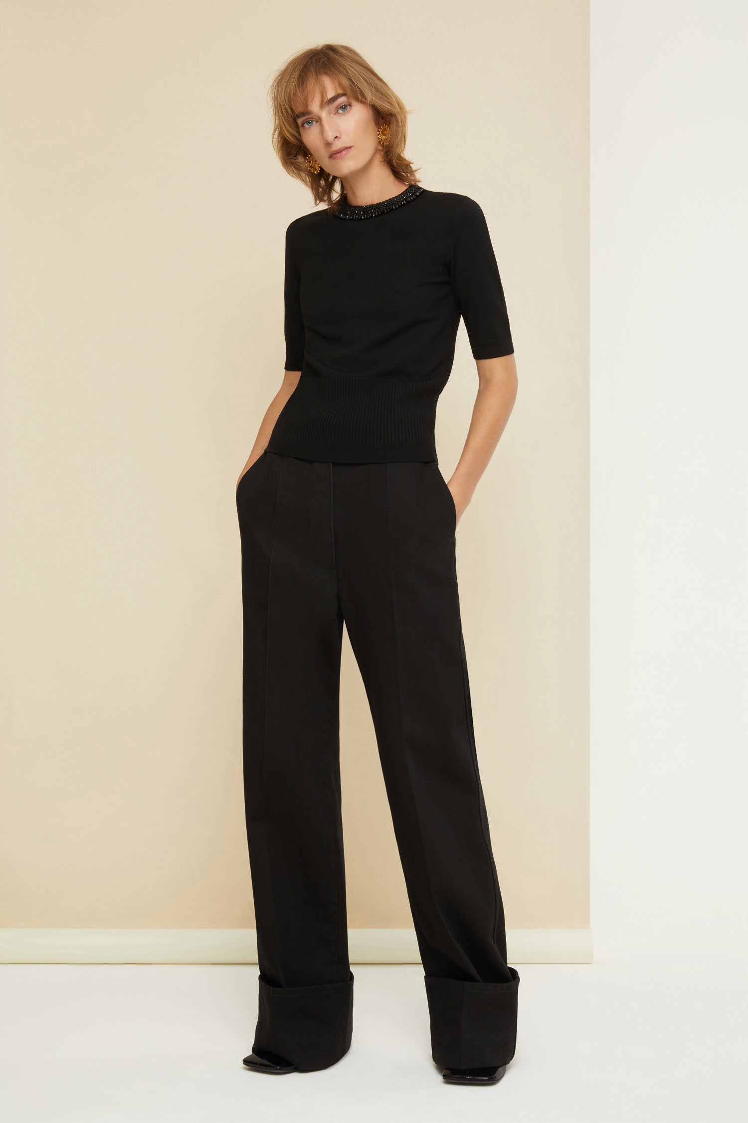 Patou - Cuffed wide-leg trousers in organic denim - Black - Cuffed and loose: denim elevated by Patou. Black organic denim trousers. Wide-legged style. Button fastening with belt loops. Pockets at the sides. Signature curved seam at the back. Wide cuffs.