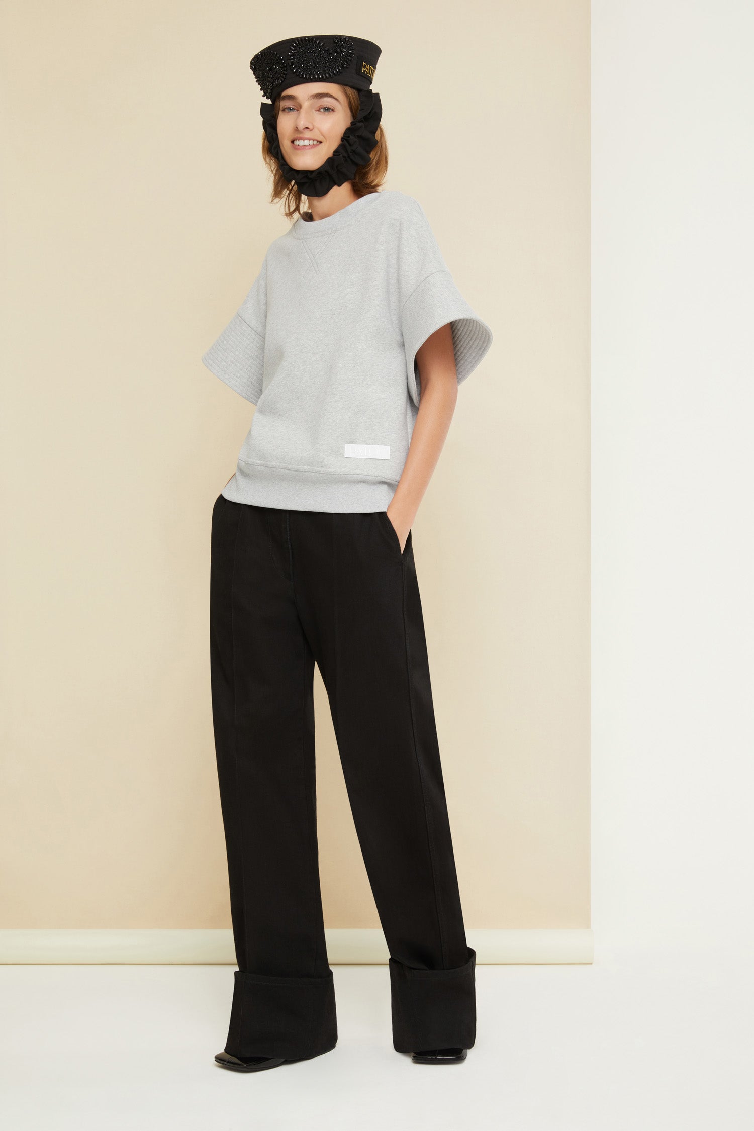 Patou - Cuffed wide-leg trousers in organic denim - Black - Cuffed and loose: denim elevated by Patou. Black organic denim trousers. Wide-legged style. Button fastening with belt loops. Pockets at the sides. Signature curved seam at the back. Wide cuffs.