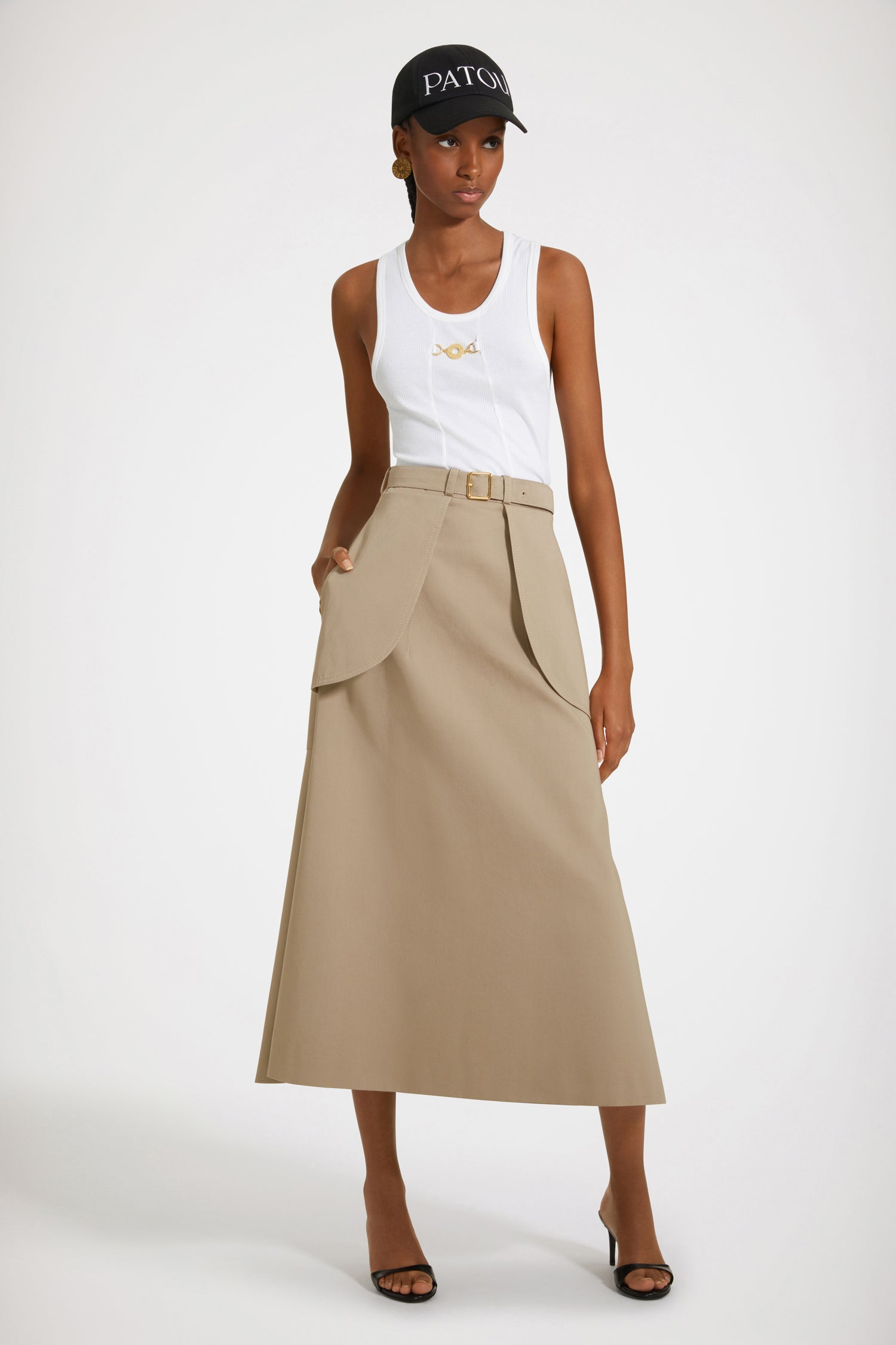 Patou - Pocket midi skirt in organic cotton - Parchment - Statement pockets make for a sensational skirt.Parchment beige organic cotton garbardine skirt. Midi length. A-line construction. Adjustable belt at the waist with gold-tone buckle and belt loops. Maxi pockets at the front. V seam and darts at the back. Tonal topstitching.