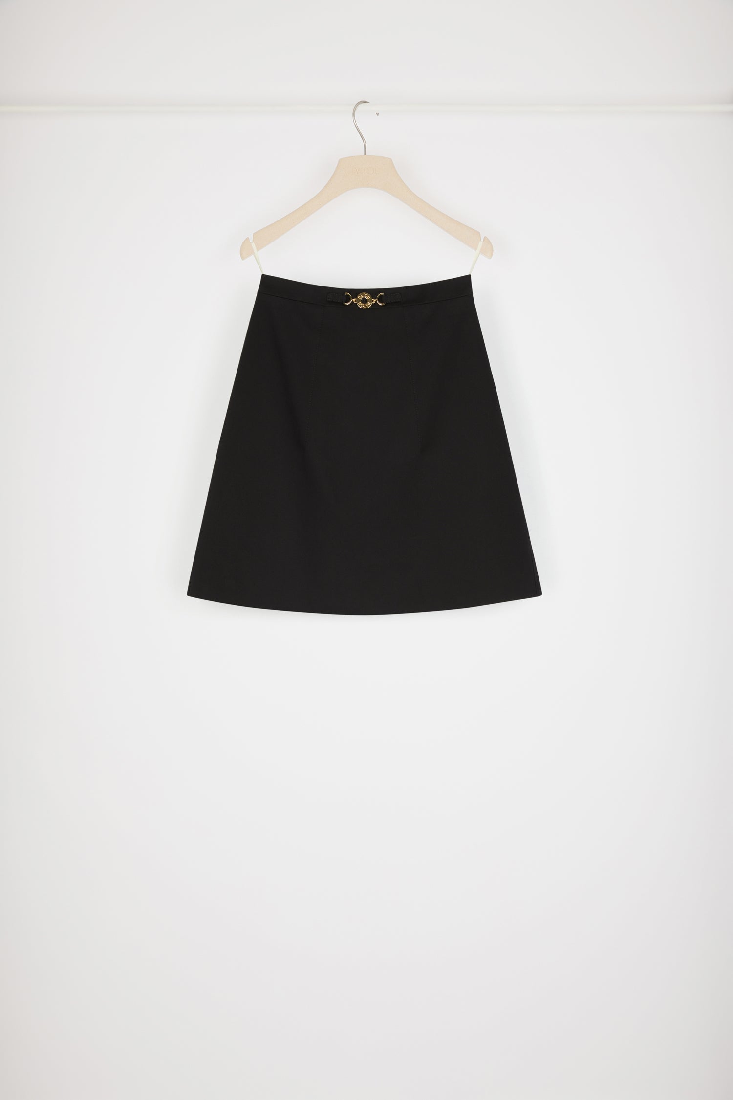 Patou - Jupe courte à médaillon en coton bio - Black - La petite jupe évasée se pare d'une touche Patou dorée. Jupe en gabardine de coton bio noir. Modèle court et évasé. Médaillon doré gravé Patou à la taille. Pinces à l'avant et au dos. Zip au dos.Le médaillon peut être enlevé.