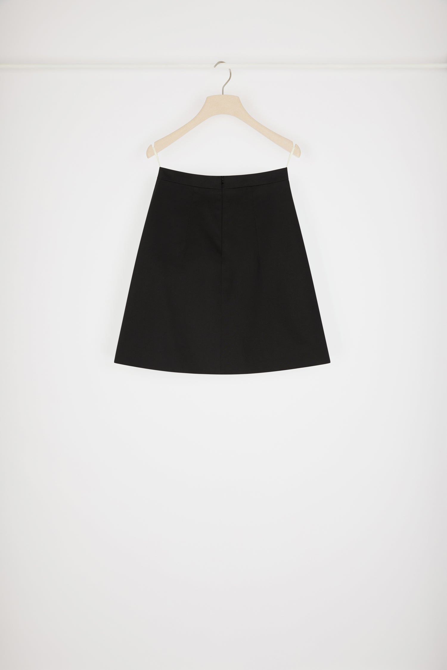 Patou - Jupe courte à médaillon en coton bio - Black - La petite jupe évasée se pare d'une touche Patou dorée. Jupe en gabardine de coton bio noir. Modèle court et évasé. Médaillon doré gravé Patou à la taille. Pinces à l'avant et au dos. Zip au dos.Le médaillon peut être enlevé.