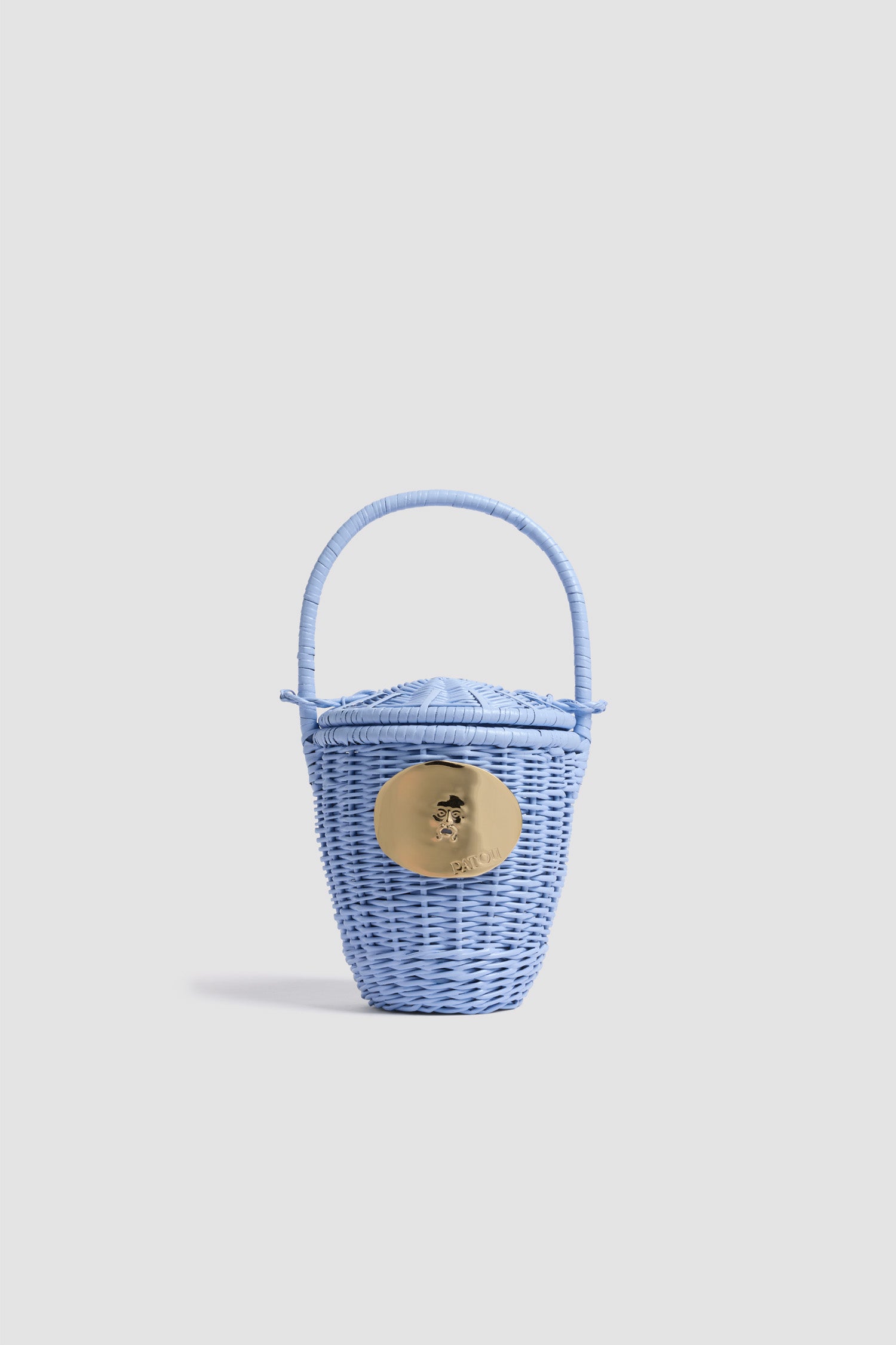 Patou - Sac Seau Iconique en Osier - Riviera Blue - Sac seau bleu clair. Matière en osier. Médaillon doré gravé Patou.