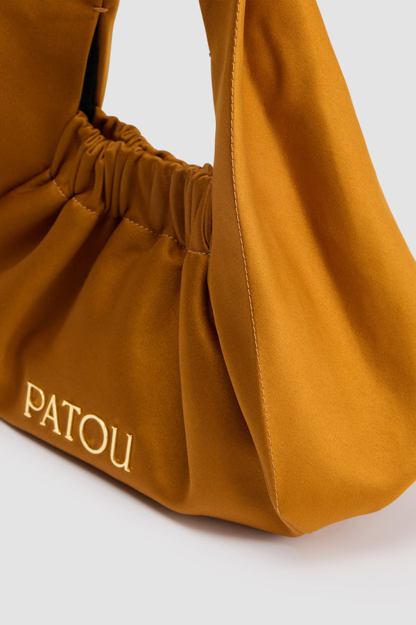 Patou - Borsa Le Biscuit in raso riciclato - Gold - Borsa in raso riciclato giallo oro. Forma a mezzaluna con manico largo. Apertura elasticizzata. Patou in metallo oro. Fodera in cotone.