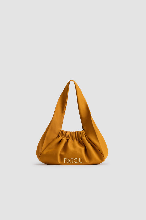 Patou - Borsa Le Biscuit in raso riciclato - Gold - Borsa in raso riciclato giallo oro. Forma a mezzaluna con manico largo. Apertura elasticizzata. Patou in metallo oro. Fodera in cotone.