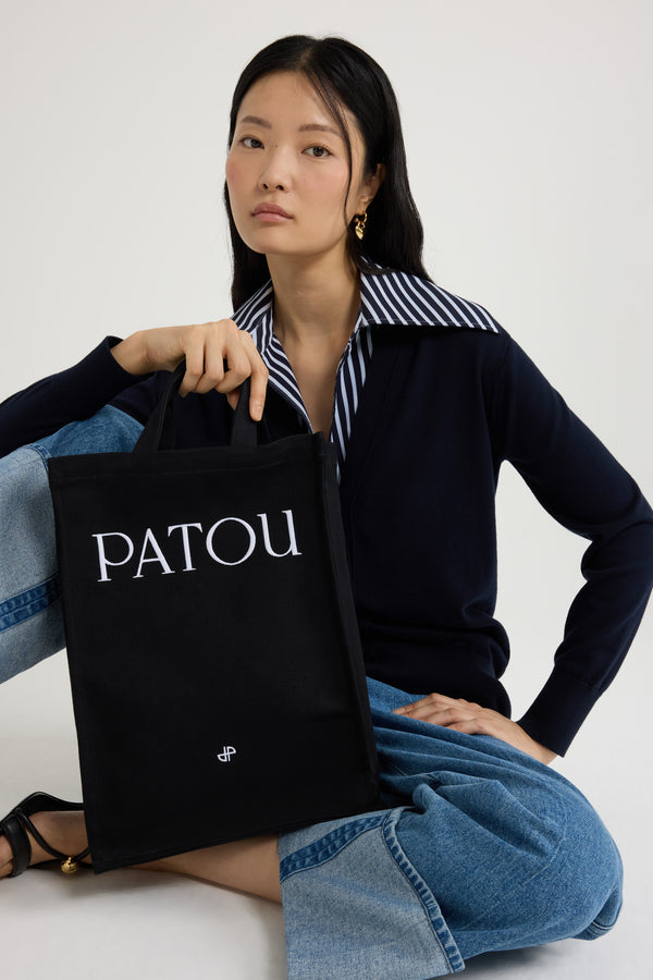 Patou - Vertical Patou tote in cotton canvas - Black - Carry your Patou everywhere with you.Black cotton canvas tote. Embroidered Patou and JP. Embossed shoulder strap with gold buttons. Two top handles. Can be carried by hand or on the shoulder.