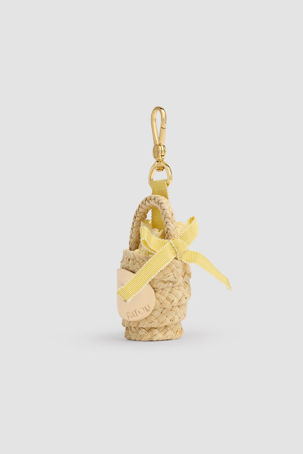 Patou - Raffia GG Korbtaschen-Anhänger - Citrus Blossom - Naturfarbener Korbtaschen-Anhänger. Material aus Raffia. Vergoldetes, graviertes Patou-Medaillon. Gelbes Band.