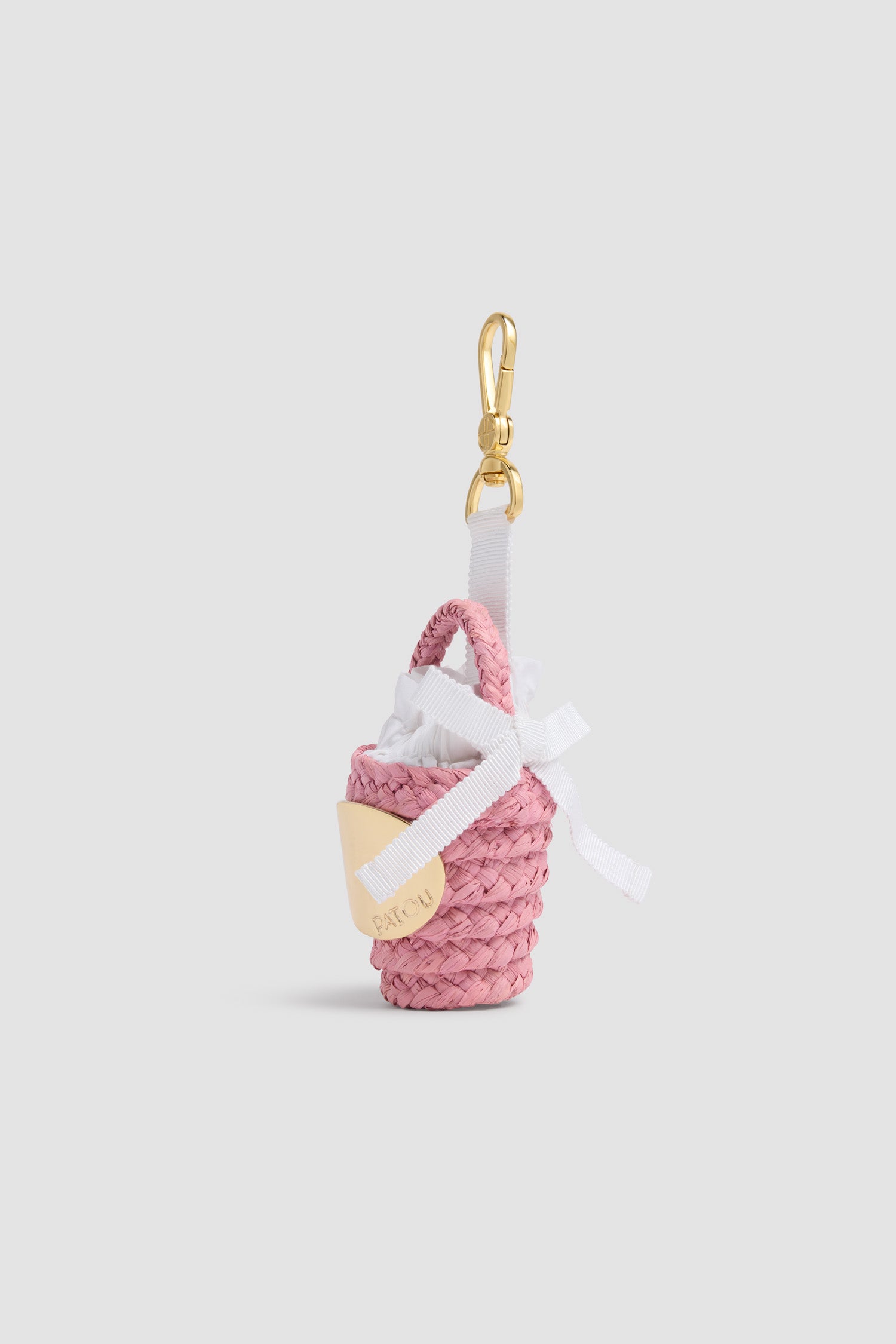Patou - Charm Borsa a Secchiello GG in Rafia - Pink Parfait - Charm a forma di borsa a secchiello rosa. Materiale in rafia. Medaglione dorato inciso Patou. Nastro bianco.