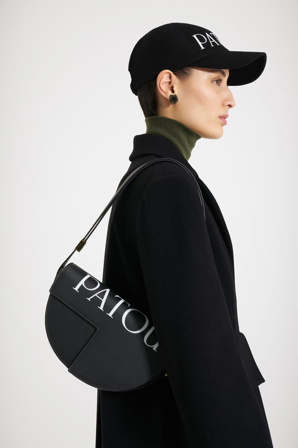 Patou - 르 파투 백 - Black and White - 업사이클링 가죽 소재로 제작된 르 파투 백. 블랙 컬러의 가죽 소재. 사용되지 않은 가죽 하이드로 만든 특수 소재만을 사용하여 제작된 백. 120점 한정 생산 리미티드 에디션. JP 모노그램에서 영감을 받은 기하학적 컷아웃이 돋보이는 반원형 실루엣. 화이트 파투 레터링 로고. 측면의 JP 모노그램 디테일 골드 톤 하드웨어. 사이즈 조절 가능한 스트랩을 활용하여 숄더백, 크로스백, 클러치로 다양하게 착용 가능. Patou가 새겨진 하드웨어. 골드 톤 JP 디테일의 자석 잠금장치. 여러 내부 수납공간. 에코 내부 마감.길이: 25 cm높이: 15 cm폭: 6 cm3가지 길이의 사이즈 조절 가능한 스트랩: 47Cm(숄더백), 36cm(크로스백), 28cm(핸드백)