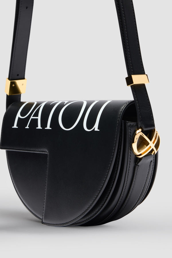 Patou - 르 파투 백 - Black and White - 업사이클링 가죽 소재로 제작된 르 파투 백. 블랙 컬러의 가죽 소재. 사용되지 않은 가죽 하이드로 만든 특수 소재만을 사용하여 제작된 백. 120점 한정 생산 리미티드 에디션. JP 모노그램에서 영감을 받은 기하학적 컷아웃이 돋보이는 반원형 실루엣. 화이트 파투 레터링 로고. 측면의 JP 모노그램 디테일 골드 톤 하드웨어. 사이즈 조절 가능한 스트랩을 활용하여 숄더백, 크로스백, 클러치로 다양하게 착용 가능. Patou가 새겨진 하드웨어. 골드 톤 JP 디테일의 자석 잠금장치. 여러 내부 수납공간. 에코 내부 마감.길이: 25 cm높이: 15 cm폭: 6 cm3가지 길이의 사이즈 조절 가능한 스트랩: 47Cm(숄더백), 36cm(크로스백), 28cm(핸드백)