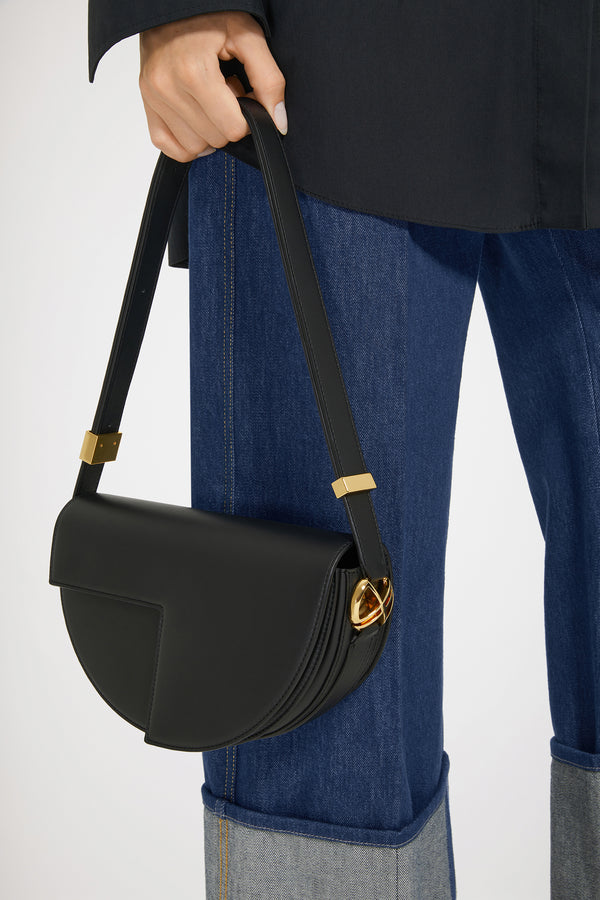 Patou - 르 파투 백 - Black - 블랙 컬러의 가죽 소재. 사용되지 않은 가죽 하이드에서 지속가능한 방식으로 공급된 독특한 소재로 제작된 리미티드 에디션. 200 개 한정 리미티드 에디션. JP 모노그램에서 영감을 받은 기하학적 컷아웃이 돋보이는 반원형 실루엣. 측면의 JP 모노그램 디테일 골드 톤 하드웨어. 길이 조절 가능한 스트랩으로 숄더백, 크로스백, 또는 토트백 스타일로 연출 가능.  골드 톤 JP 디테일의 자석 잠금장치. 여러 내부 수납공간. 길이: 25 cm높이: 15 cm폭: 6 cm3가지 길이의 사이즈 조절 가능한 스트랩: 47Cm(숄더백), 36cm(크로스백), 28cm(핸드백)