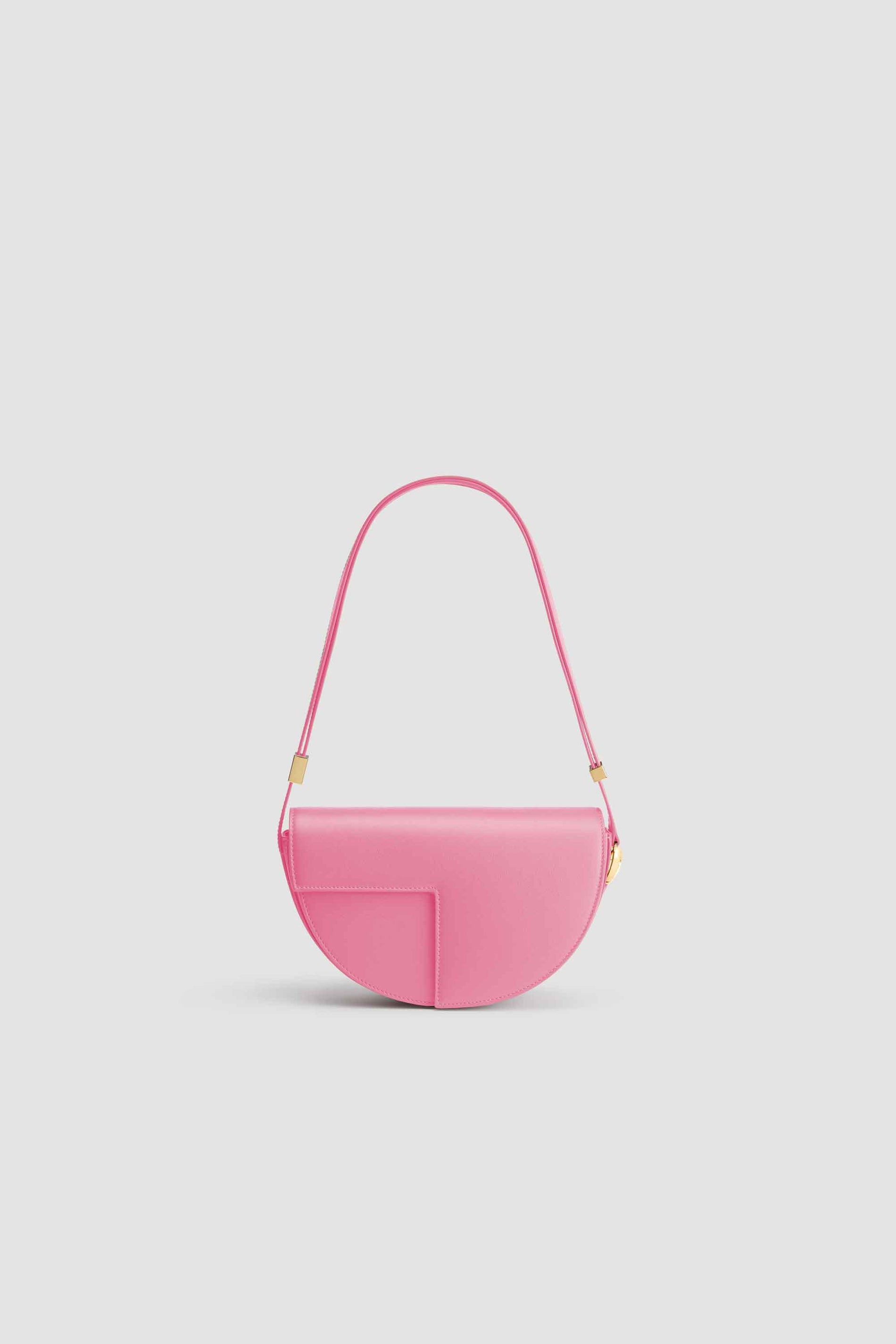 Patou - Le Patou - Pink - Le Patou a plus d&amp;#39;un tour dans son sac !Sac en cuir rose. Édition limitée et numérotée disponible en 60 exemplaires. Forme demi-lune avec découpes géométriques inspirée du monogramme JP. Pièces en métal doré avec détail JP inspiré d&amp;#39;une broche des archives Jean Patou. Bandoulière ajustable permettant un porté épaule, en bandoulière ou à la main. Fermeture aimantée avec détail JP doré. Compartiments multiples à l&amp;#39;intérieur.Dimensions : 25 cm de longueur, 15 cm de hauteur et 6 cm de profondeur.Bandoulière ajustable en 3 longueurs : 47 cm (sur l&amp;#39;épaule), 36 cm (en bandoulière), 28 cm (porté à la main)