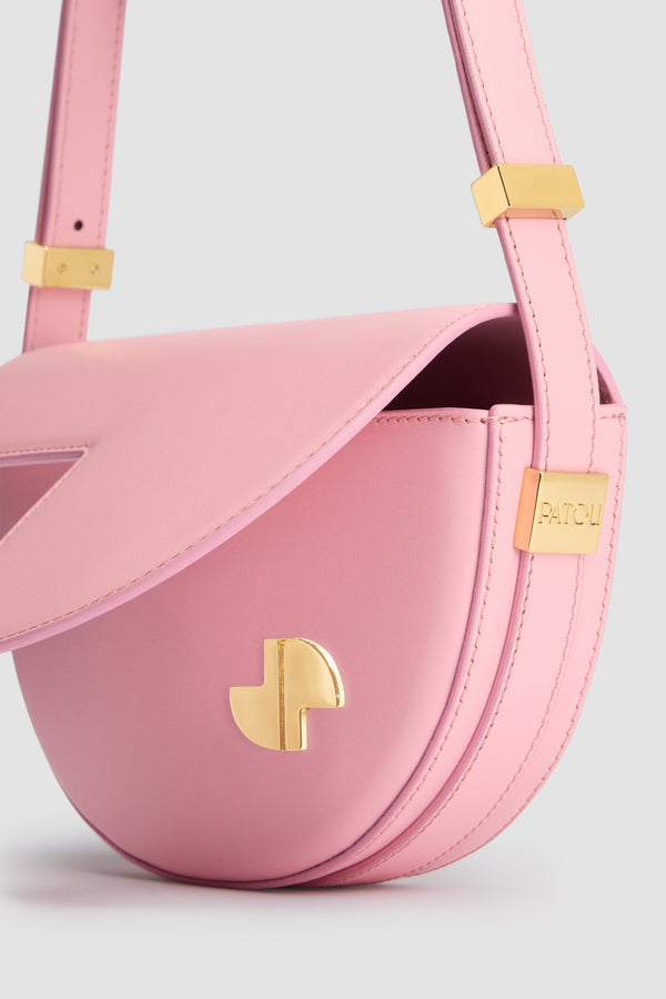 Patou - Le Petit Patou bag in leather - Rosebloom Pink - Rosebloom Pink leather handbag. Half-circle shape with geometric cut-outs inspired by the JP monogram. Gold-tone hardware with Patou-engraved detail at the side. Adjustable strap that allows it to be worn on the shoulder, across the body or carried by hand. Magnetic closure with gold-tone JP detail. Internal compartment. Eco lining.Measures: 20 cm (length), 13 cm (height), 5 cm (depth)