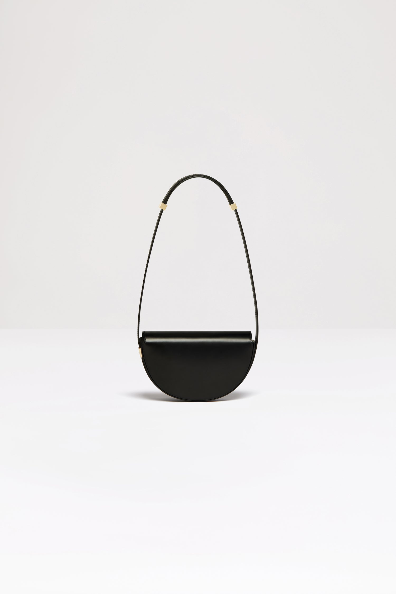 Patou - Le Petit Patou bag in leather - Black - A smaller take on everyone&amp;#39;s favourite piece of Patou!Black leather handbag. Crafted using unique materials sourced from unused high-quality leather hides. 80 limited numbered edition. Half-circle shape with geometric cut-outs inspired by the JP monogram. Gold-tone hardware with Patou-engraved detail at the side. Adjustable strap that allows it to be worn on the shoulder, across the body or carried by hand. Magnetic closure with gold-tone JP detail. Internal compartment. Eco lining.Measures: 20cm (length), 13cm (height), 5cm (depth)