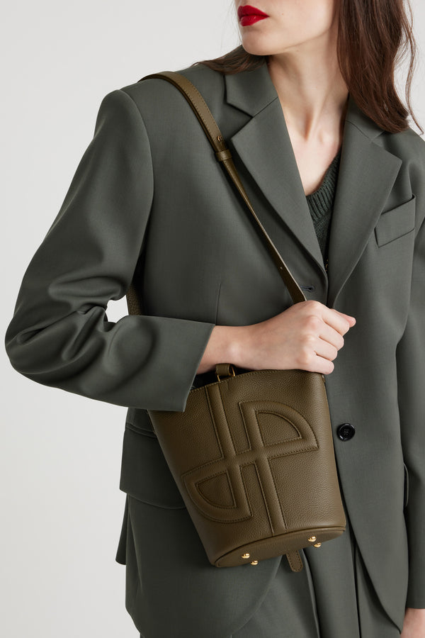 Patou - Piccola borsa a secchiello JP in pelle - Winter Moss - Borsa in pelle sgranata verde muschio. Modello piccolo. Forma a secchiello con JP in 3D sul davanti. Chiusura con cinghia. Tracolla rimovibile e regolabile. Parti metalliche oro. Piedini in metallo.