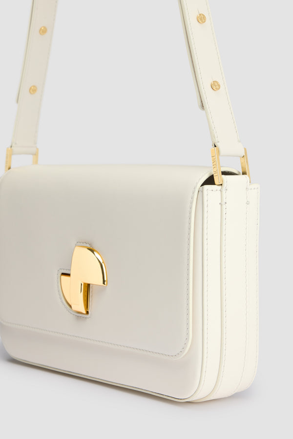 Patou - レザー Le Classic Lock バッグ - Angora - アンゴラオフホワイトのレザー製ハンドバッグ。ひねりを効かせた、クラシックなデイバッグ。フロントにゴールドのアールデコ調JPツイストクラスプ。肩掛けまたは手持ちのどちらでも持ち運べる調節可能なストラップ付き。レザーライニング。