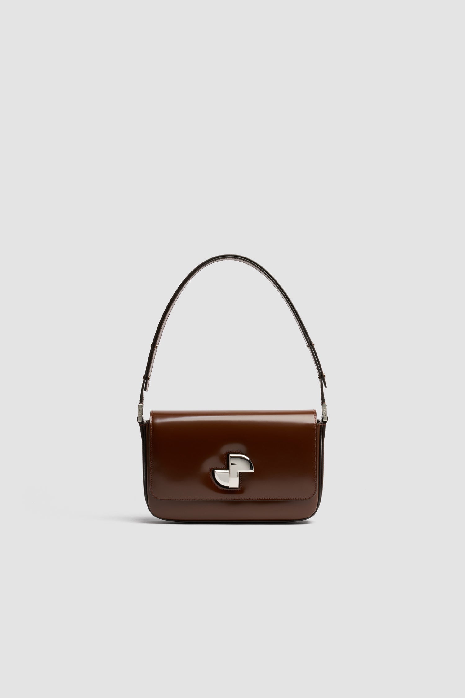 Patou - Sac Le Classic Lock en cuir - Smoked Ebony - Sac à main en cuir brillant couleur ébène fumé. Sac de jour classique revisité. Fermoir rotatif JP doré d’inspiration Art Déco sur le devant. Bandoulière réglable pouvant être portée courte ou longue. Doublure en cuir.
