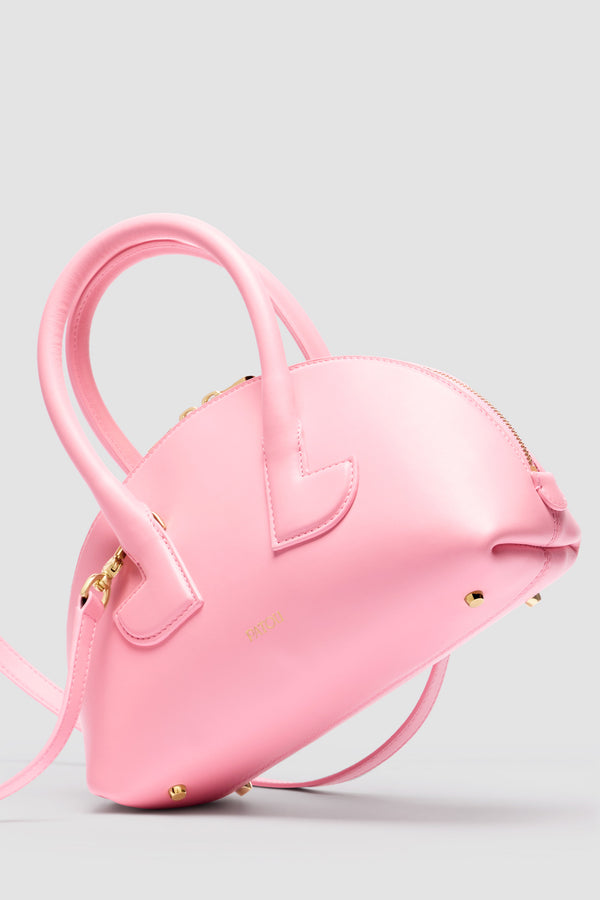 Patou - Borsa Le Patou Bowling in pelle - Primrose Pink - Borsa in pelle liscia rosa. Forma bowling. Doppio manico con dettagli geometrici. Tracolla rimovibile. Chiusura con zip oro a doppio cursore. Logo Patou oro sul davanti. Piedini in metallo oro.