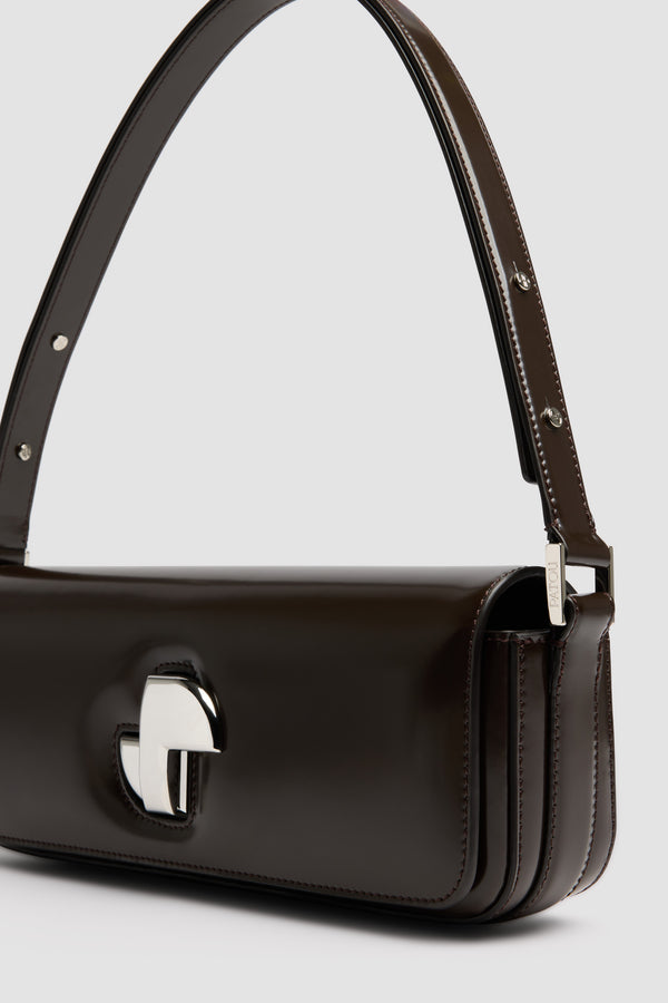 Patou - Le Lock Tasche aus Leder - Smoked Ebony - Tasche aus glänzendem Leder in Rauchig-Ebenholz. Klassische Tasche mit länglicher Form. Goldener Art déco-JP-Drehverschluss an der Vorderseite. Durch den verstellbaren Riemen kann sie kurz oder lang getragen werden. Innenfutter aus Leder.