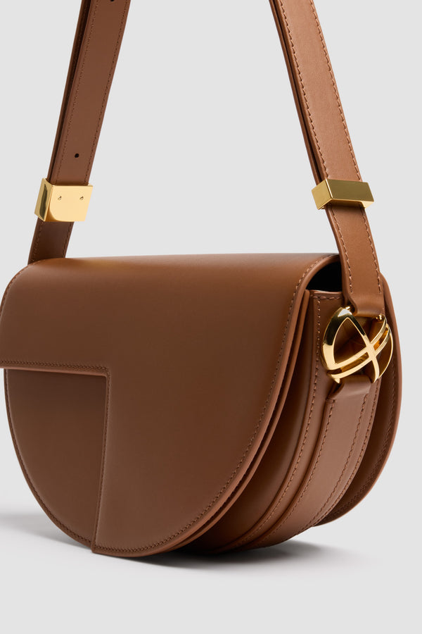 Patou - Borsa Le Patou in pelle - Mahogany - Borsa in pelle liscia mogano. Forma a mezzaluna con tagli geometrici ispirati al monogramma JP. Pezzi in metallo oro con monogramma JP sul lato. Tracolla regolabile che consente di portare la borsa a spalla, a bandoliera o a mano. Chiusura magnetica con dettaglio JP oro. Compartimenti interni multipli.Dimensioni: 25 cm (lunghezza), 15 cm (altezza), 6 cm (larghezza)Tracolla regolabile con tre lunghezze: 47 cm (sulla spalla), 36 cm (crossbody), 28 cm (a mano)